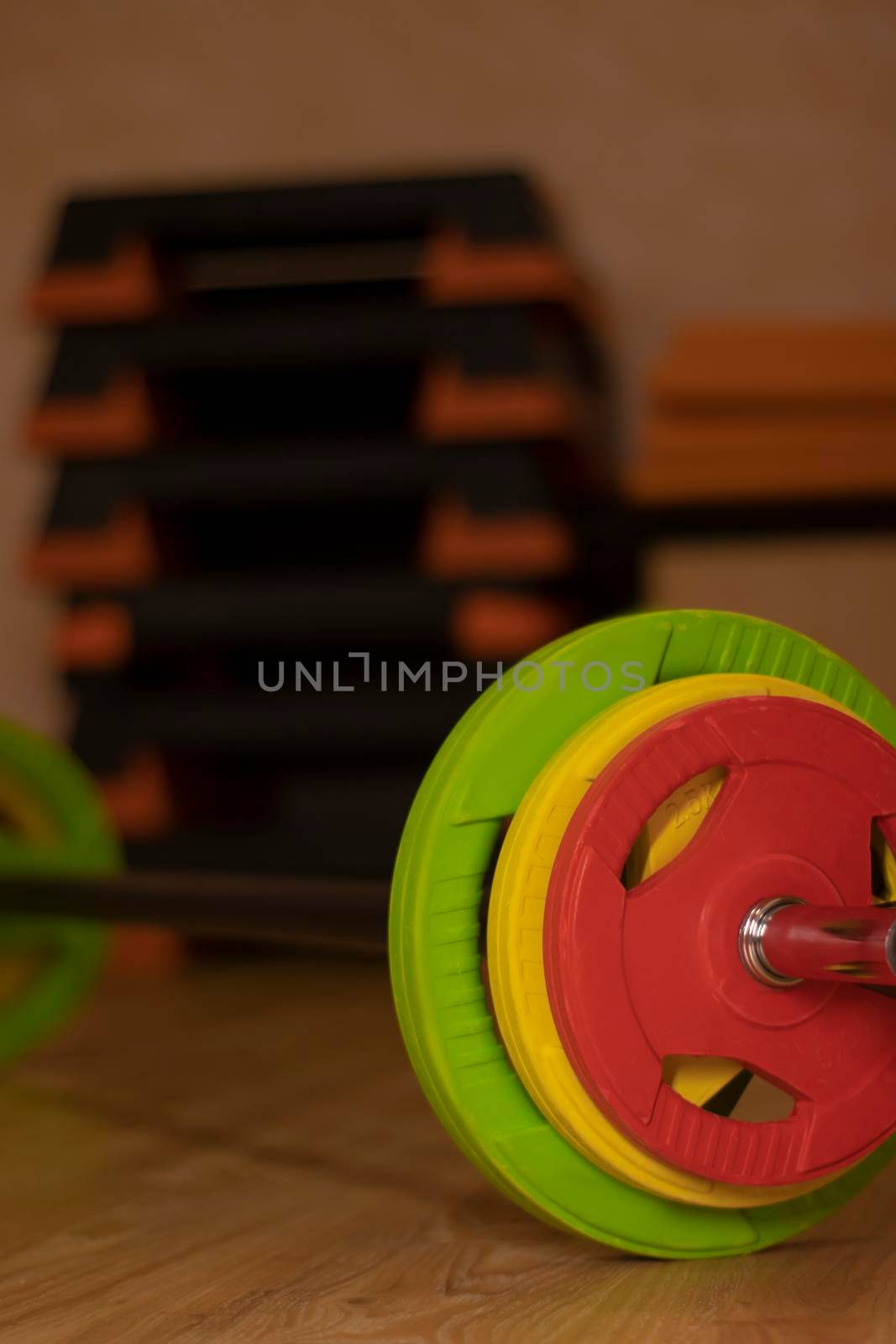 a bar with three multi-colored damn bar - red, yellow and green. In the gym. Sport concept. by oliavesna