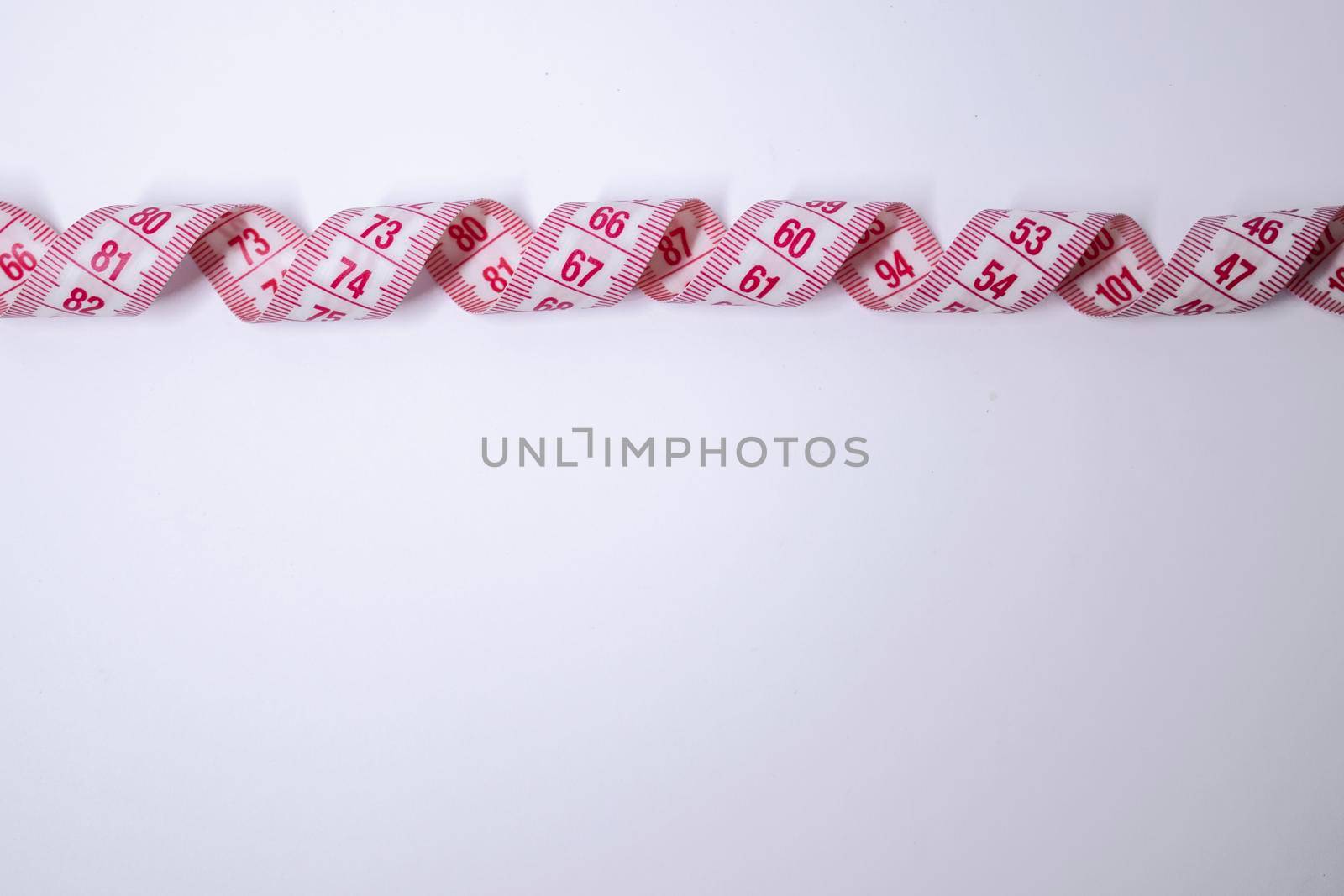 Red measuring tape on white background. Loss weight concept. Top view. Copy space. Isolated. . High quality photo