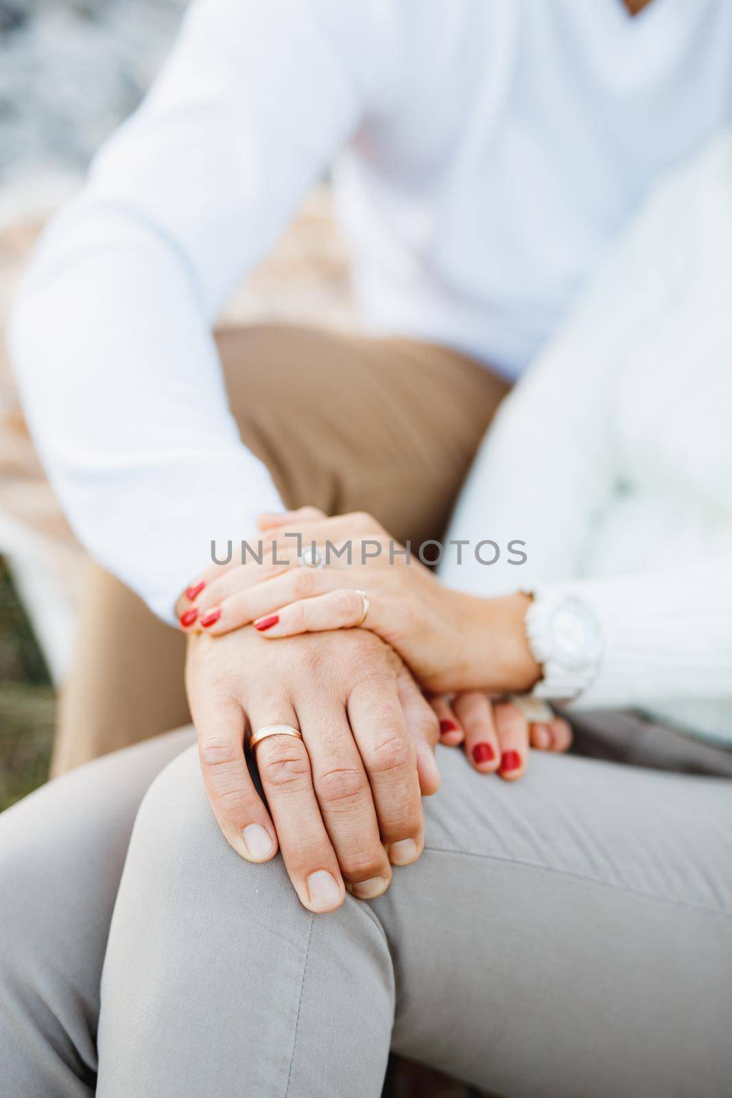 Woman's hand covered the man's hand. Man's hand lies on woman's leg. Close up. High quality photo