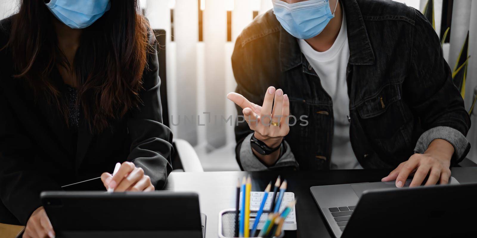 Business People wear mask at meeting to discuss and brainstorming the financial report paperwork in home office. Financial advisor teamwork and accounting concept by itchaznong