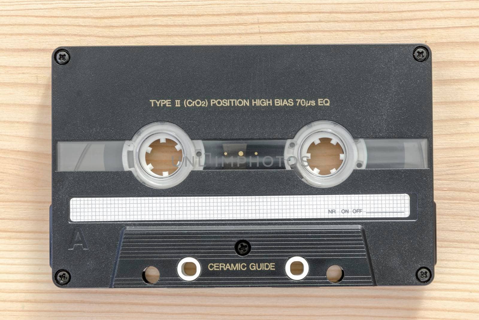 chrome type vintage audio cassette on the light wooden background
