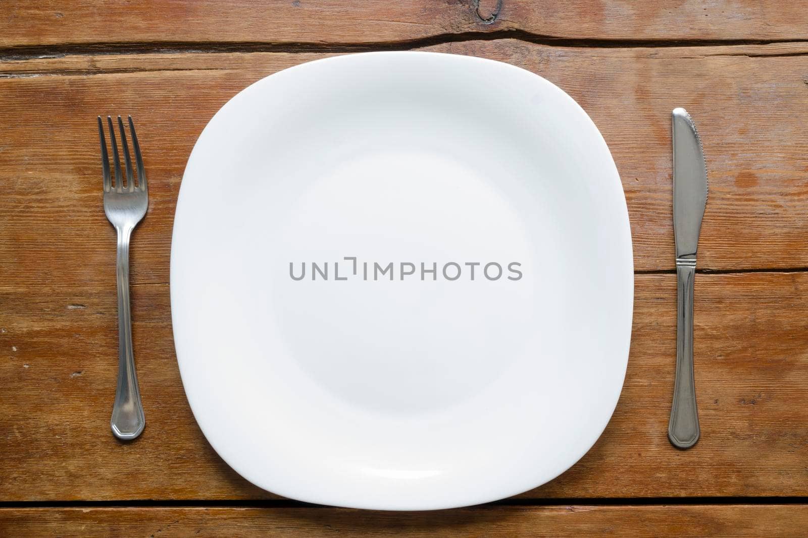 empty plate with fork and knife on the vintage wooden table