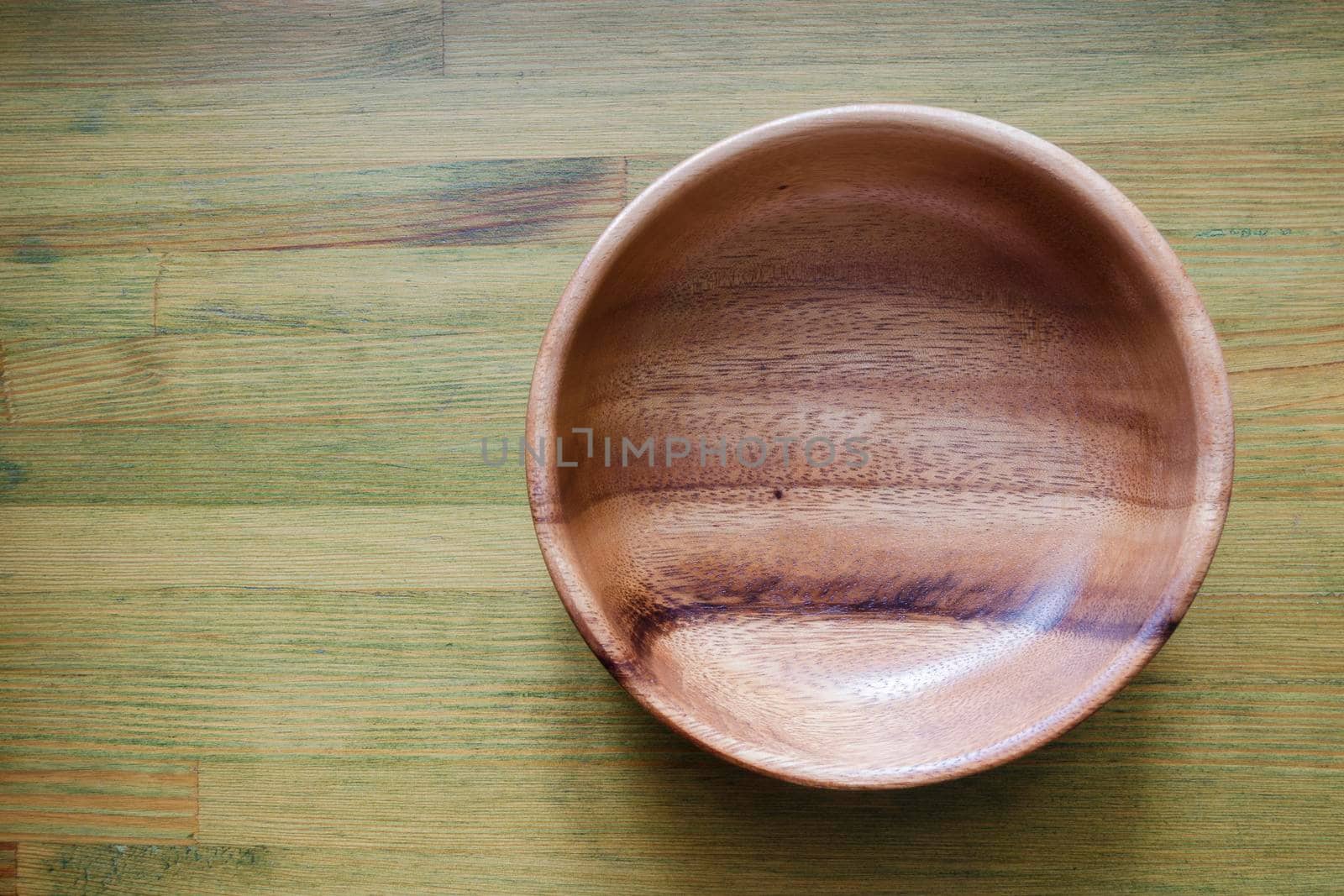 empty wooden bowl on green wooden table