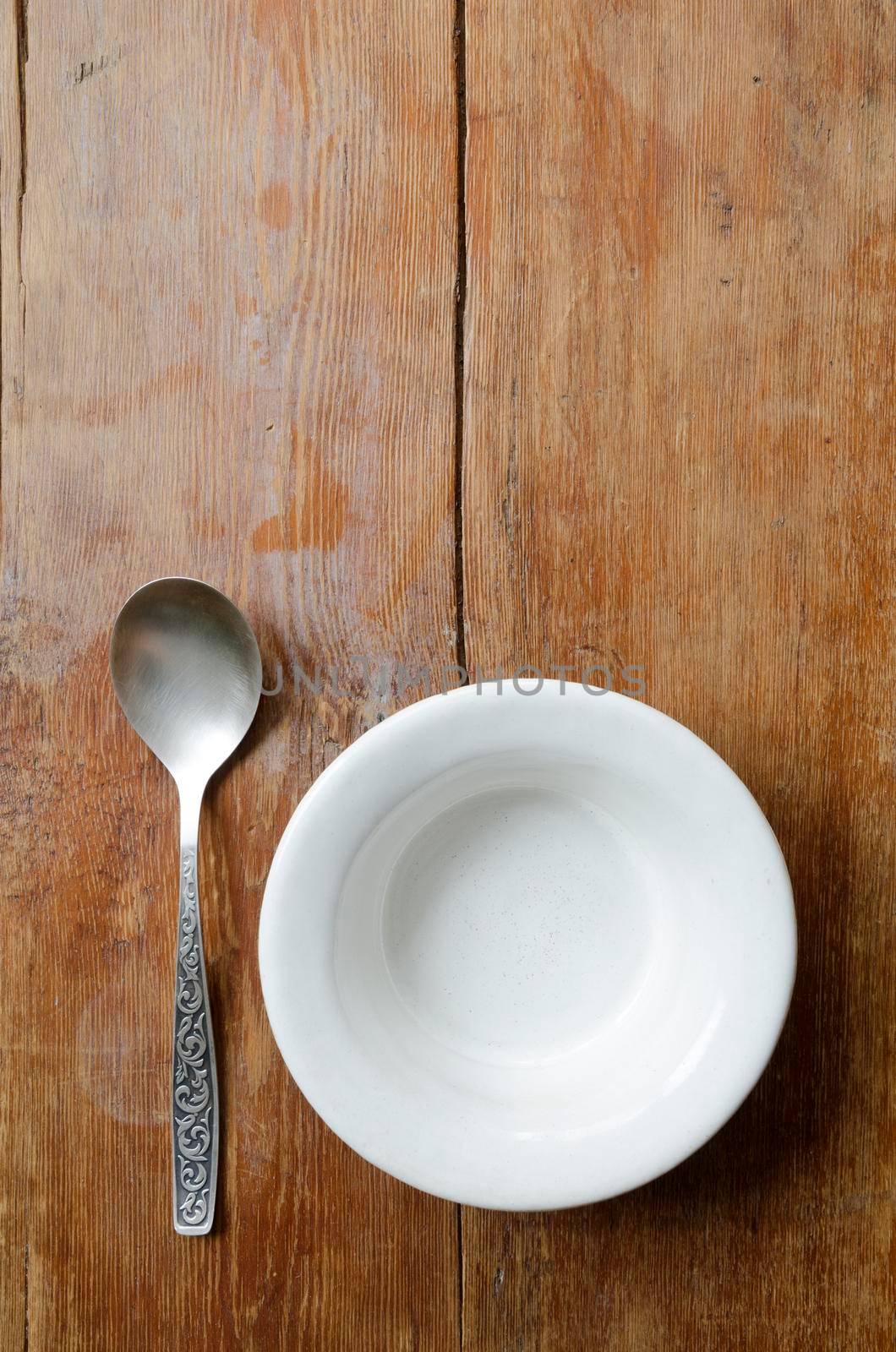 empty bowl vertical image with silver spoon on vintage wooden background