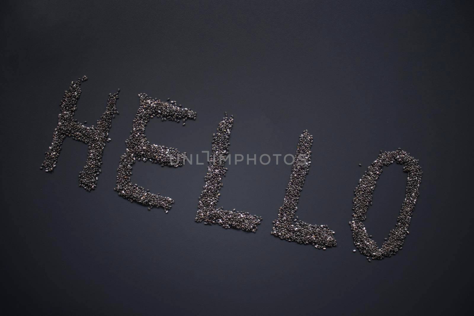 Word 'HELLO' written with chia seeds on gray background, top view, copy space.