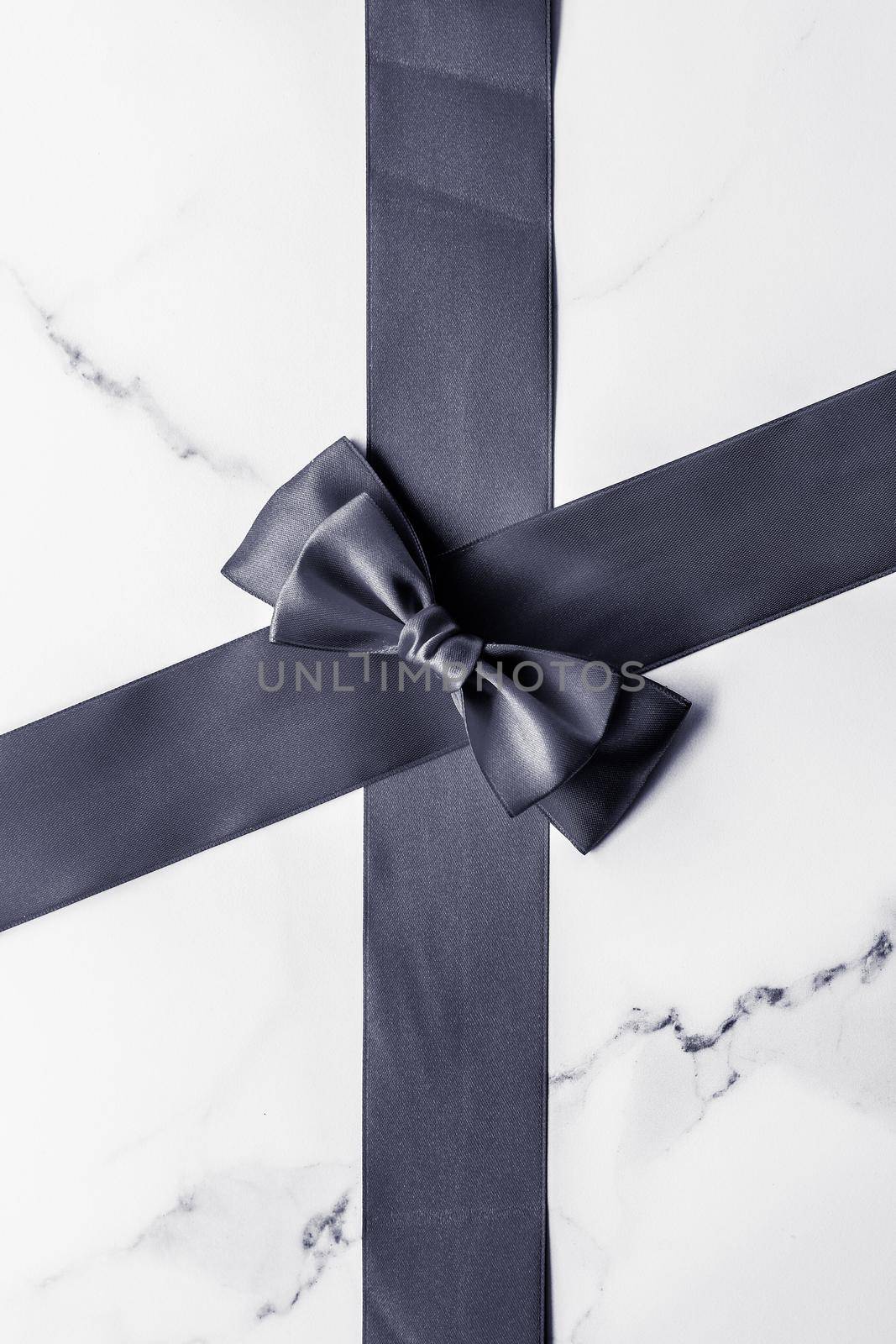 Holiday gift, decoration and sale promotion concept - Black silk ribbon and bow on marble background, flatlay