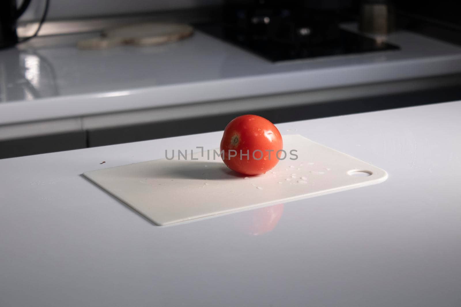 cutting white plastic board with a tomato on it. cooking process. High quality photo