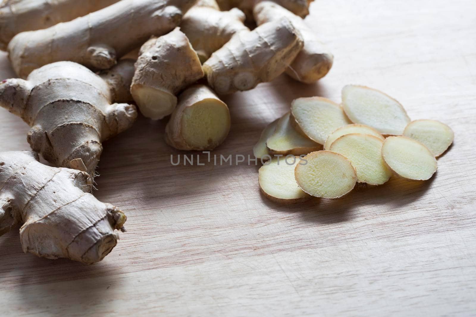 Ginger root and slices on cutting board