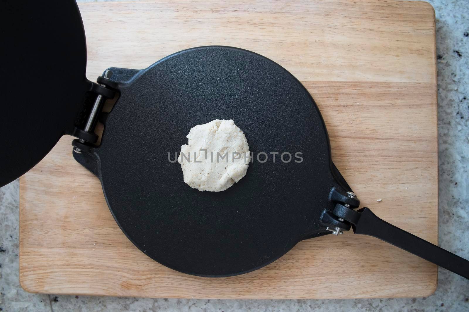 Dough for corn tortilla on press viewed from above.