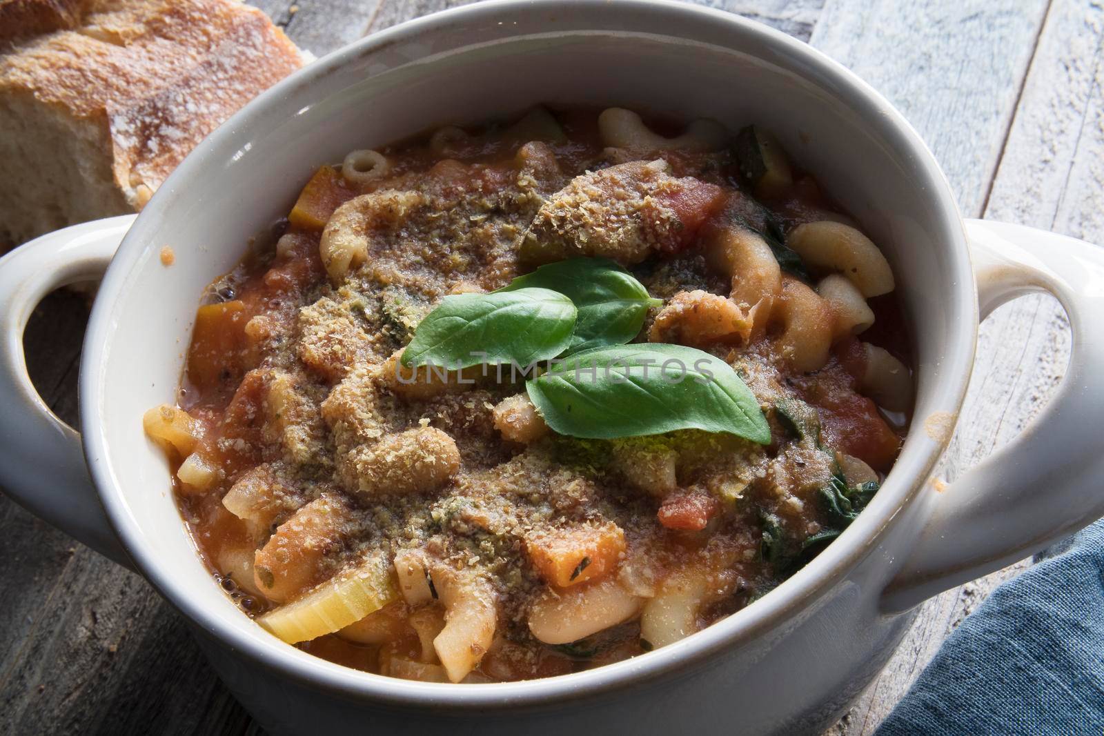 Thick and hearty vegetarian minestrone soup topped with basil