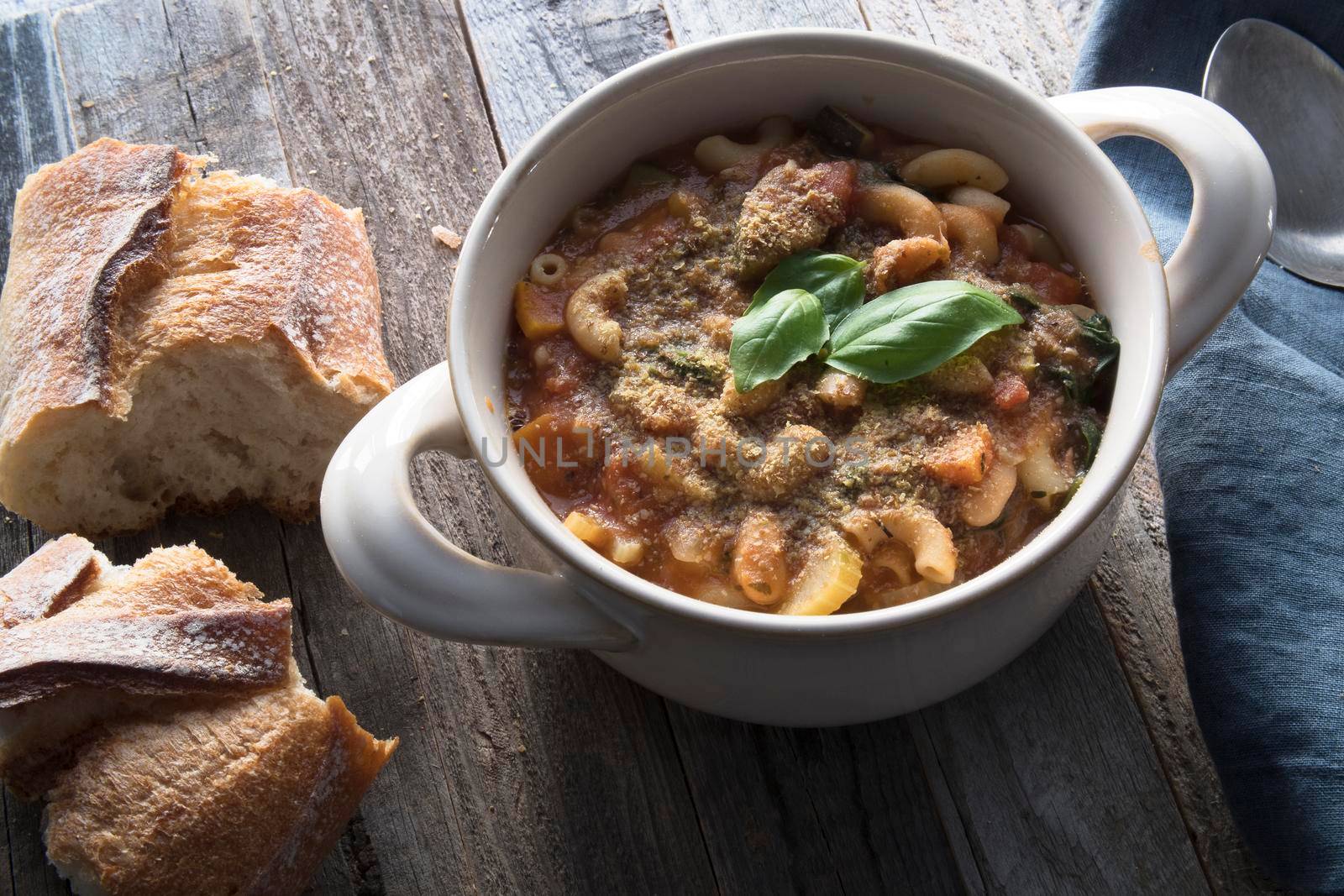 Thick and hearty vegetarian minestrone soup topped with basil