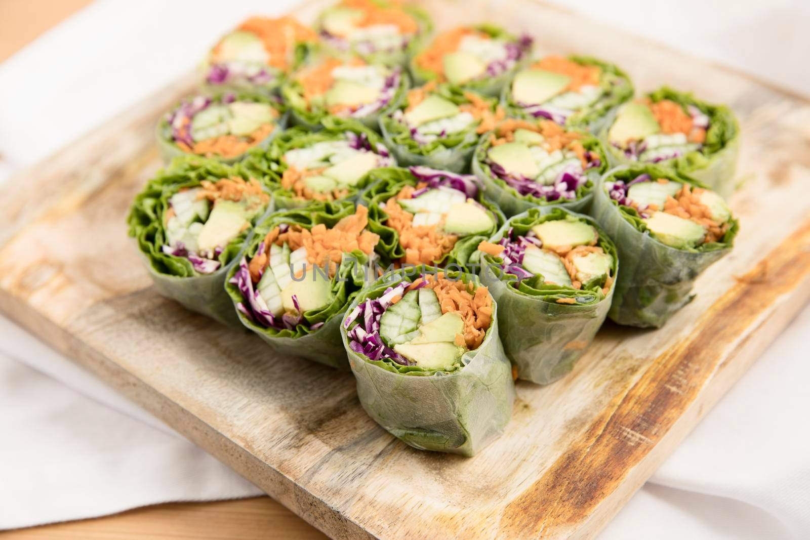 Vegetarian spring rolls with avocado, carrots, cucumber and red cabbage.