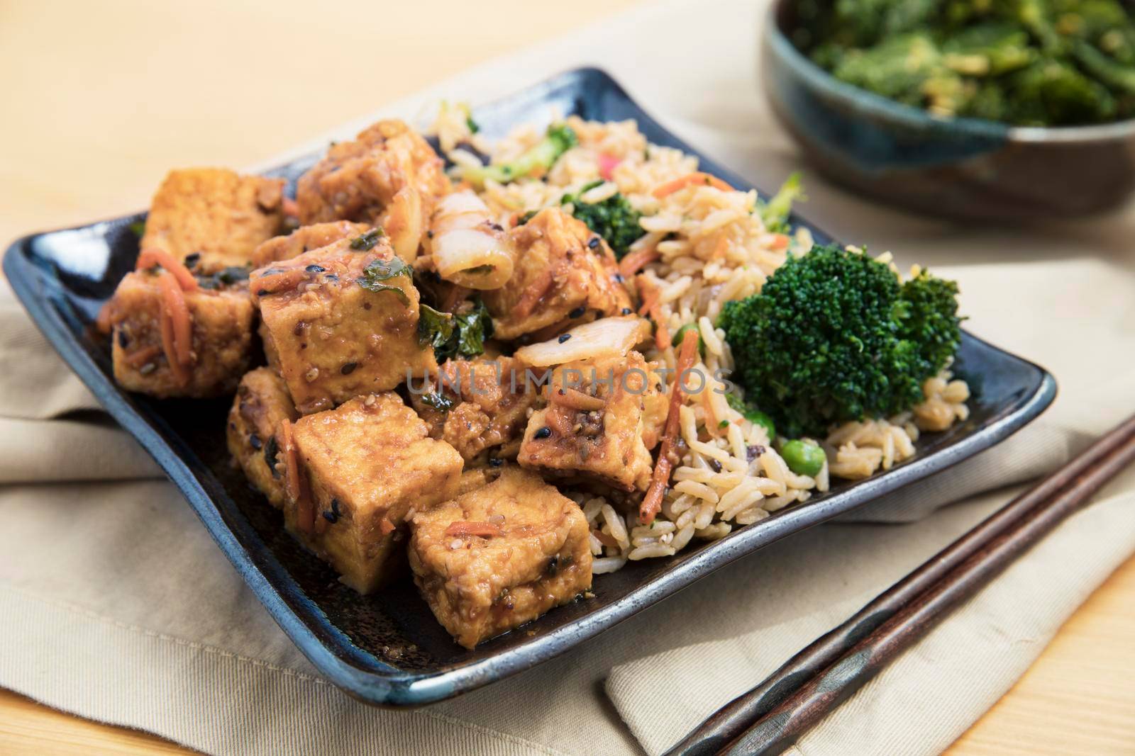 Fried tofu with rice and vegetable stir fry vegan asian meal.