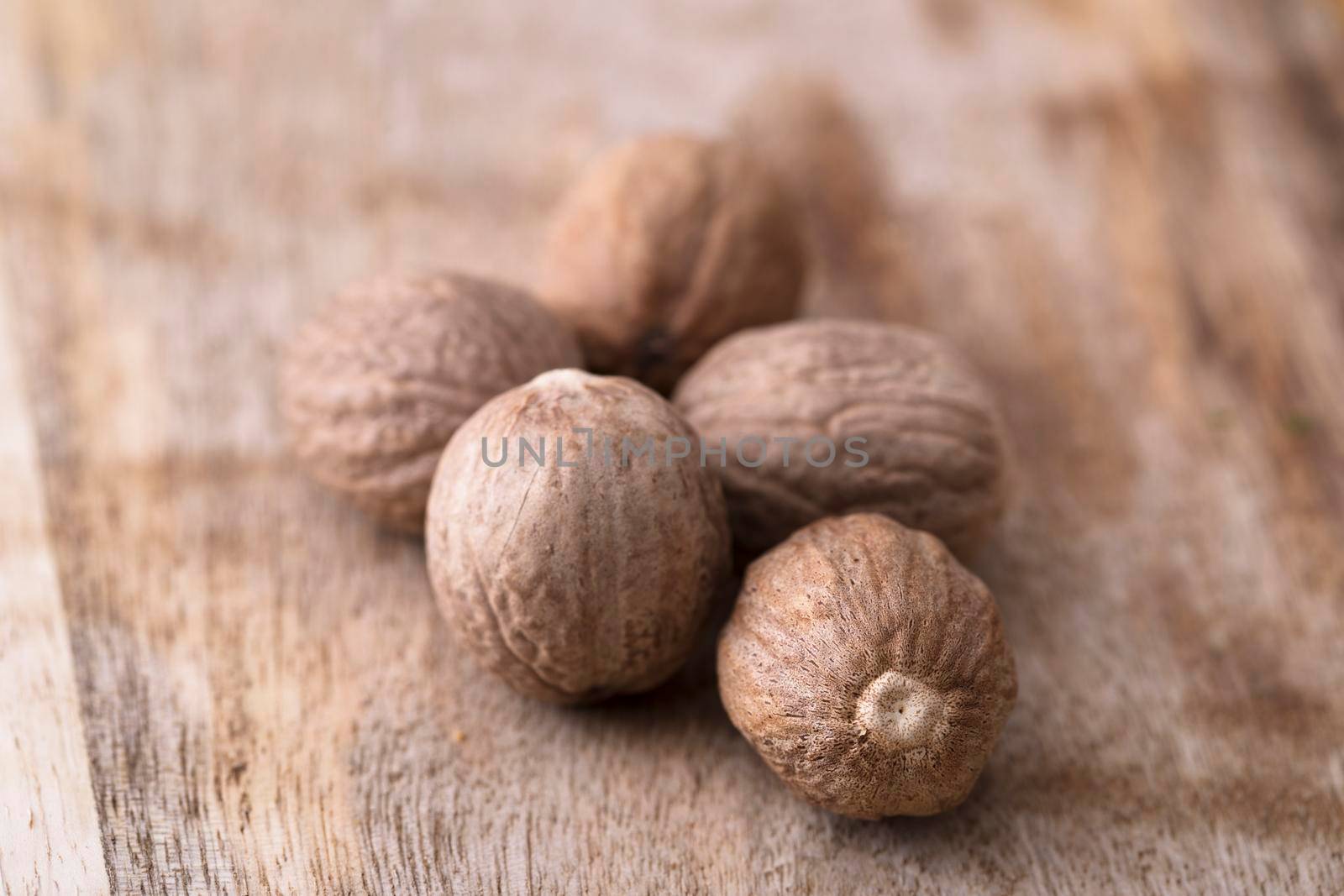 Whole nutmeg on rustic wooden surface