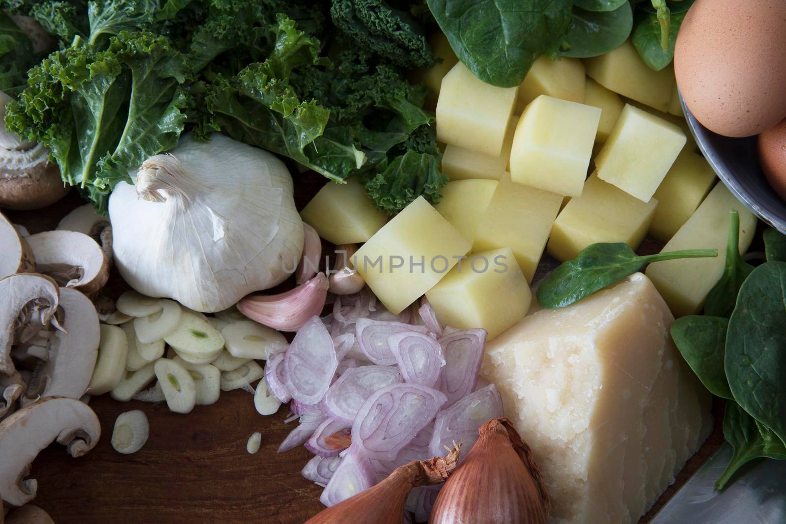 Fresh ingredients with parmesan, shallots, garlic, mushrooms, potatoes and kale.