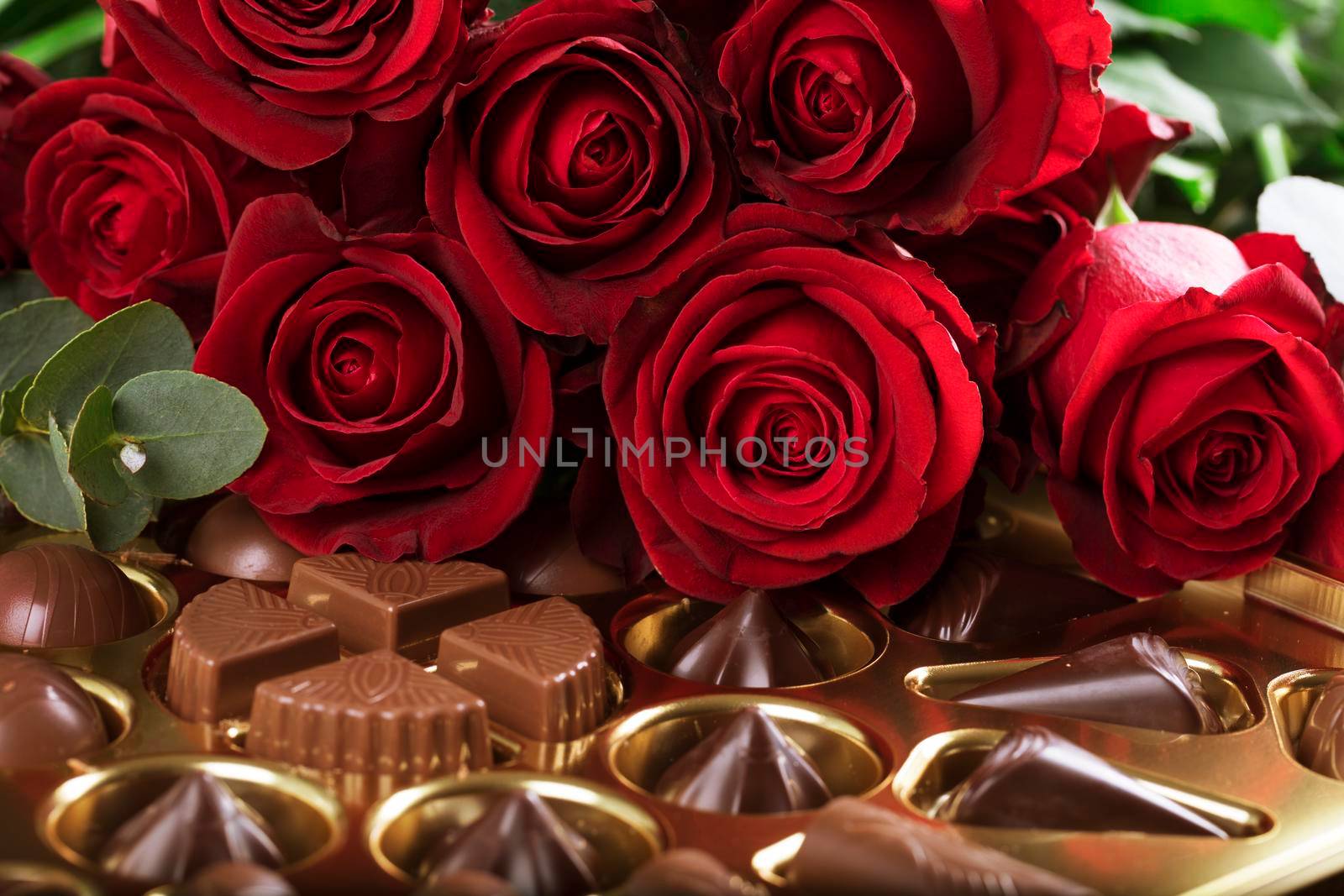 Vibrant red roses on a box of chocolates for valentine's day, or any day to say I love you.