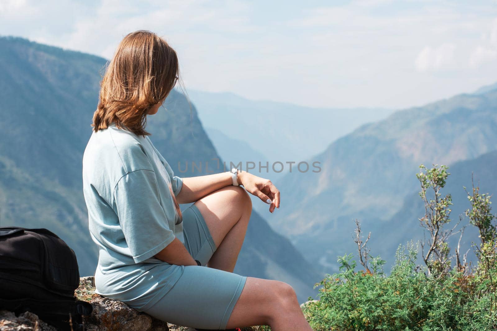 Domestic tourism, travel, lesure and freedom concept after pandemic- woman on the top of Altai mountain, beauty summer evening landcape