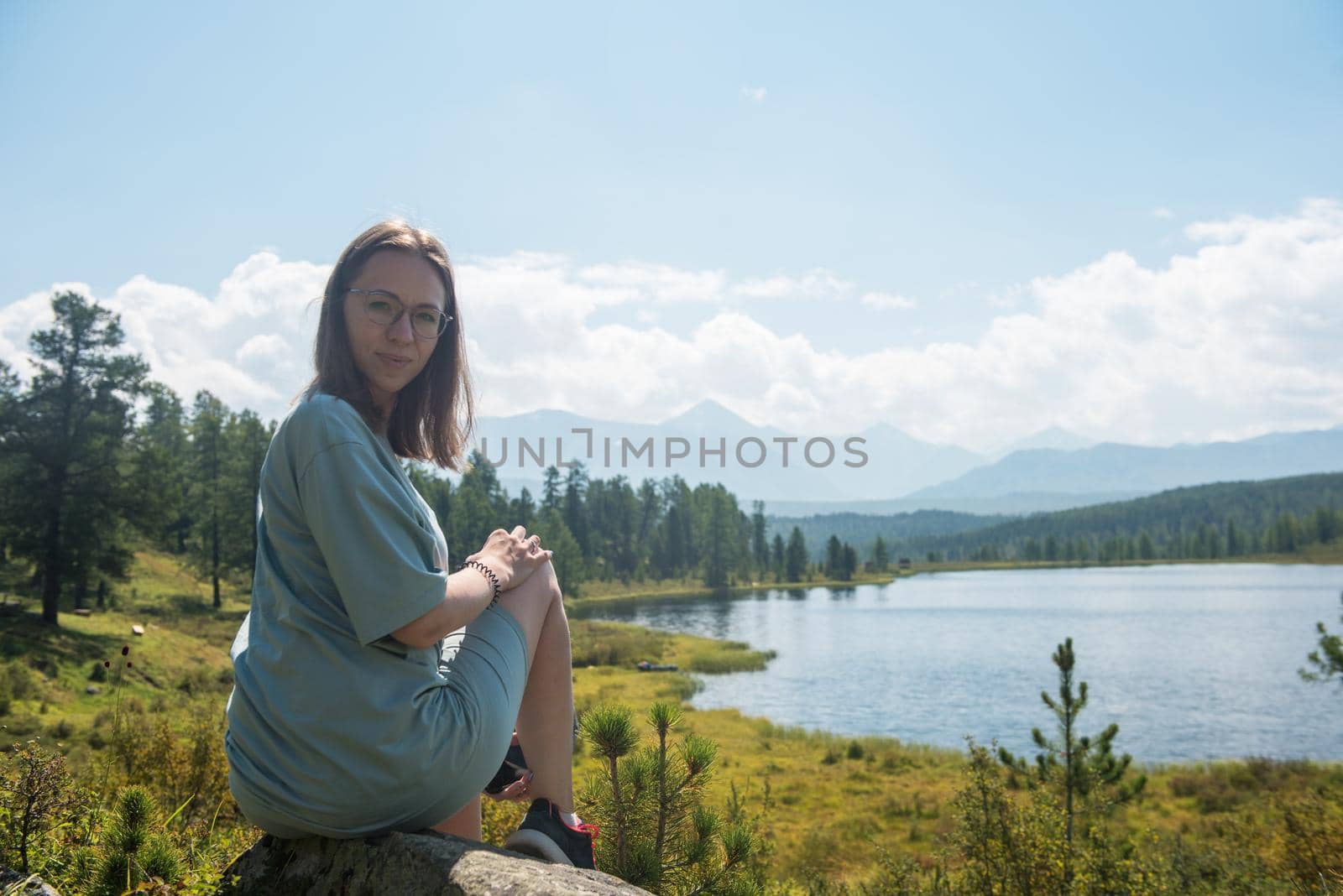 Woman resting at mountain lake in summer, Altai mountains