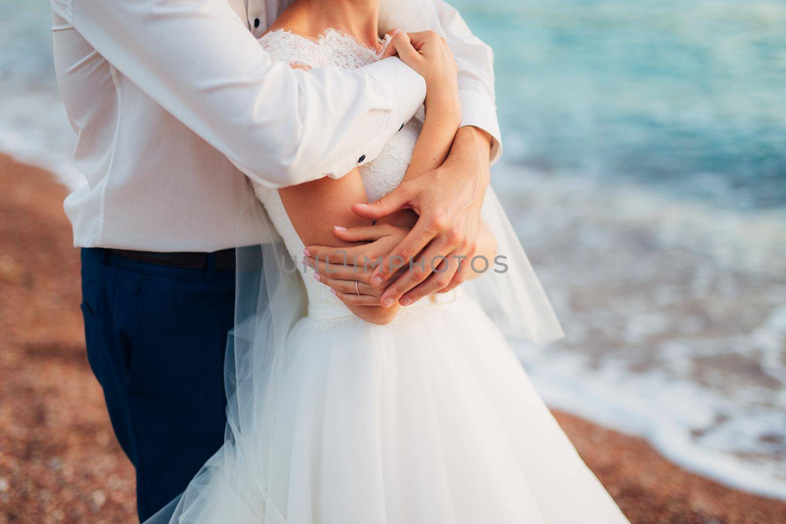 Newlyweds hug each other in Montenegro by Nadtochiy