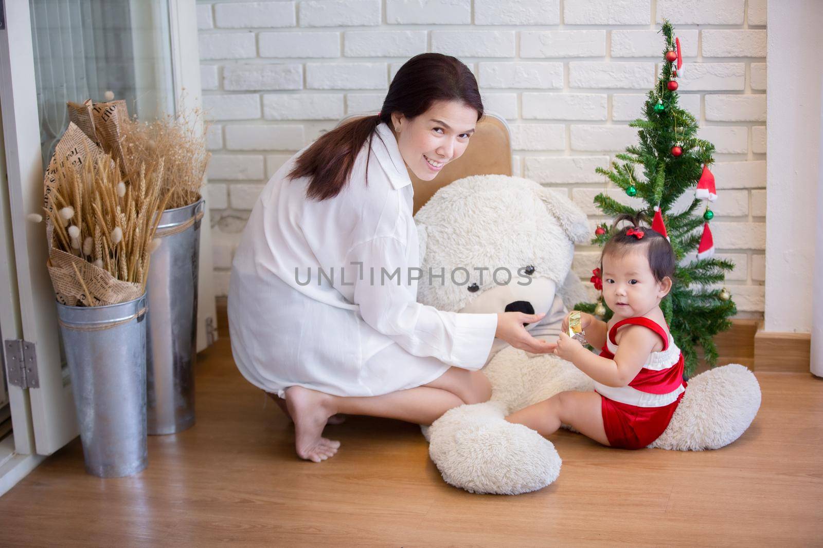 Full Length Of Cute Baby Girl Wearing Santa Costume While Sitting With Christmas Decorations by chuanchai
