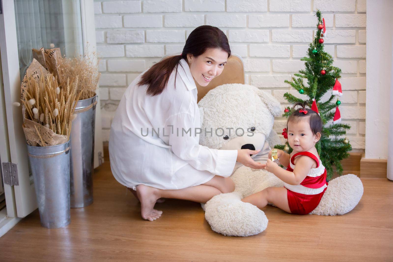 Full Length Of Cute Baby Girl Wearing Santa Costume While Sitting With Christmas Decorations