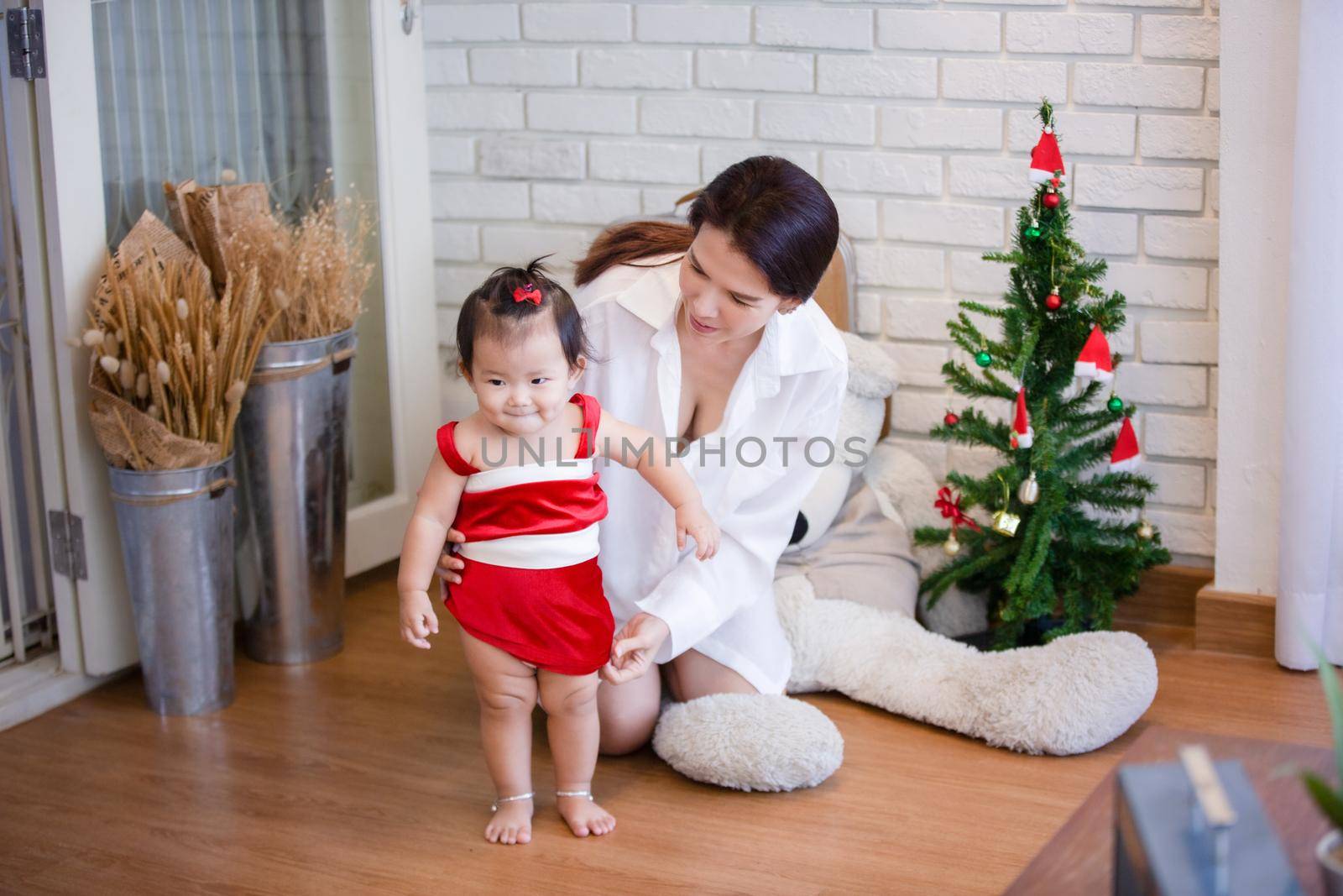 Full Length Of Cute Baby Girl Wearing Santa Costume While Sitting With Christmas Decorations