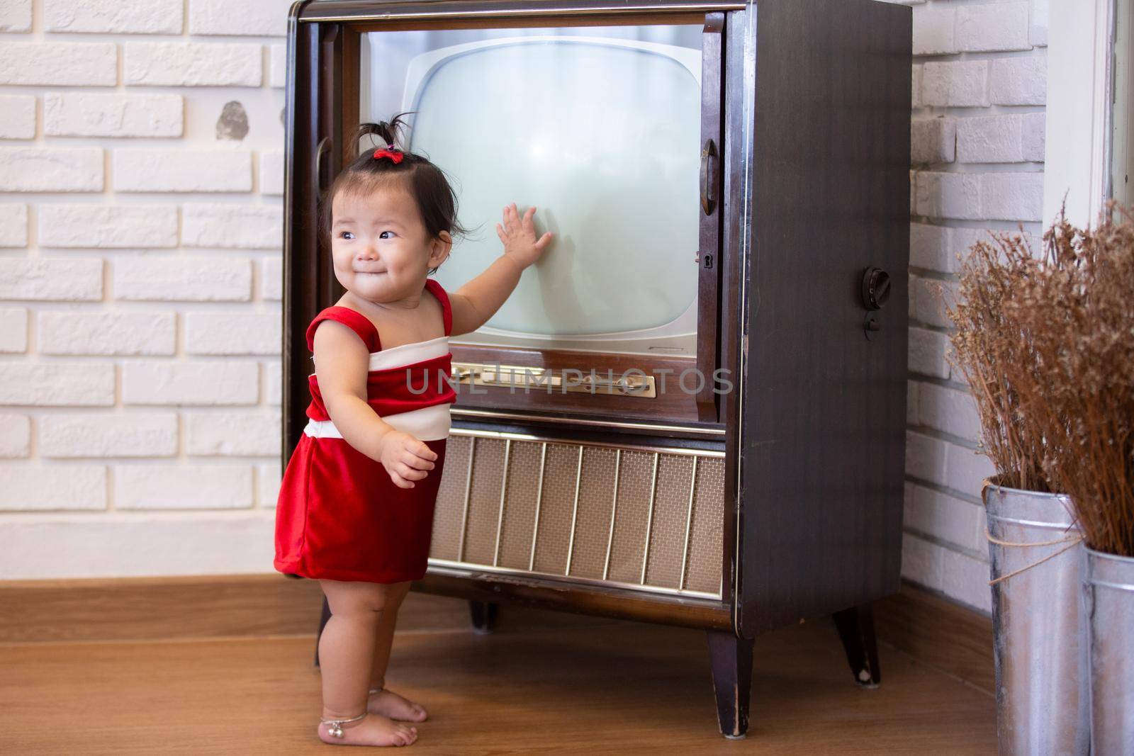 Full Length Of Cute Baby Girl Wearing Santa Costume While Sitting With Christmas Decorations by chuanchai