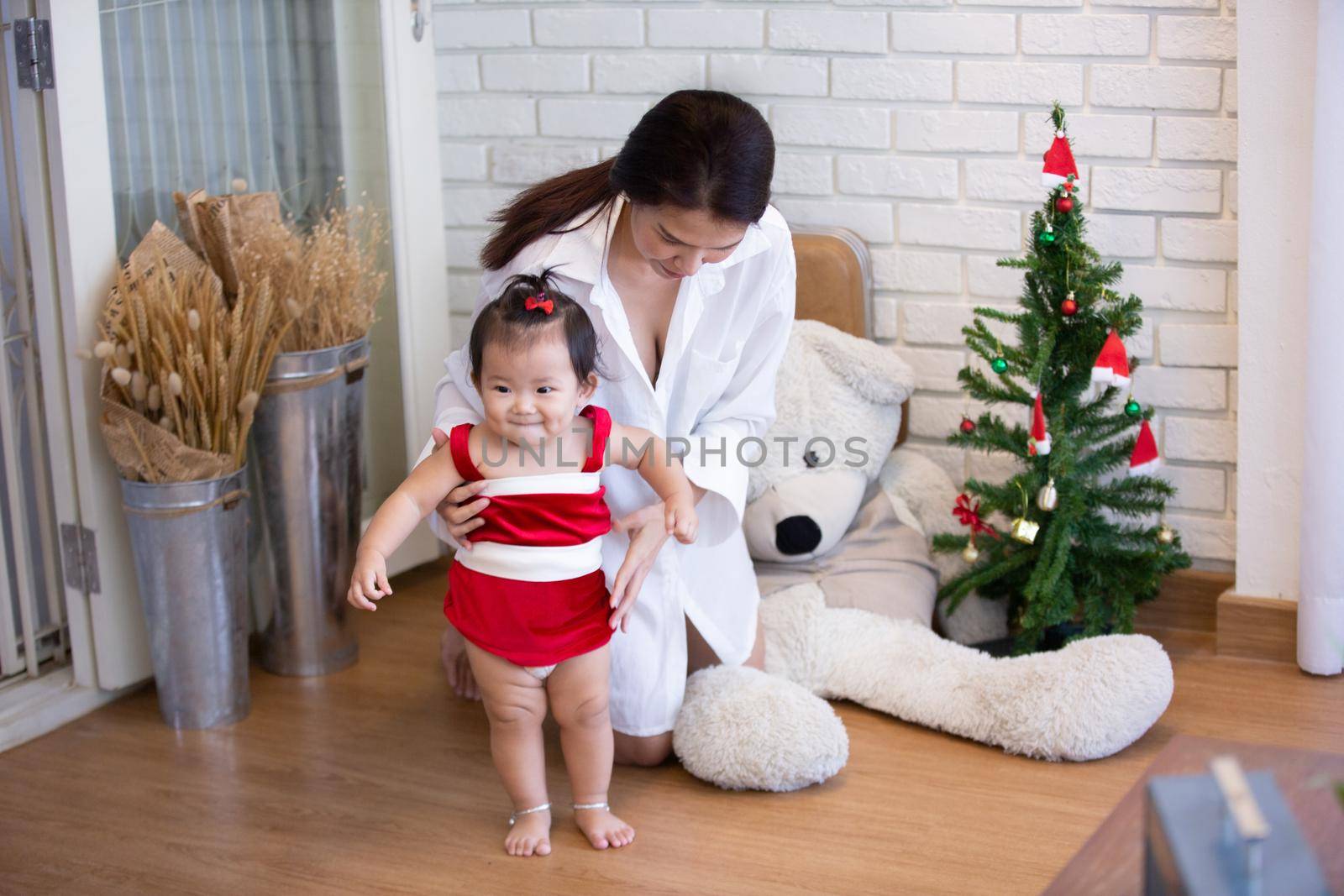 Full Length Of Cute Baby Girl Wearing Santa Costume While Sitting With Christmas Decorations by chuanchai