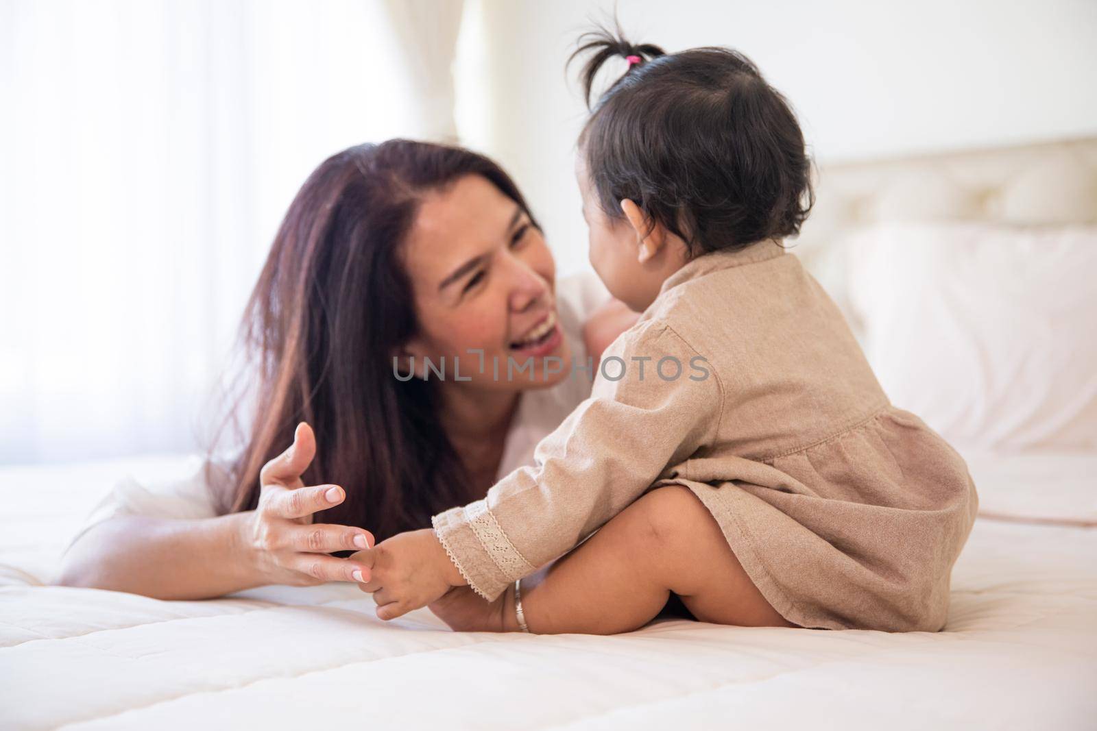 Loving and affectionate mother holding newborn baby indoors at home.