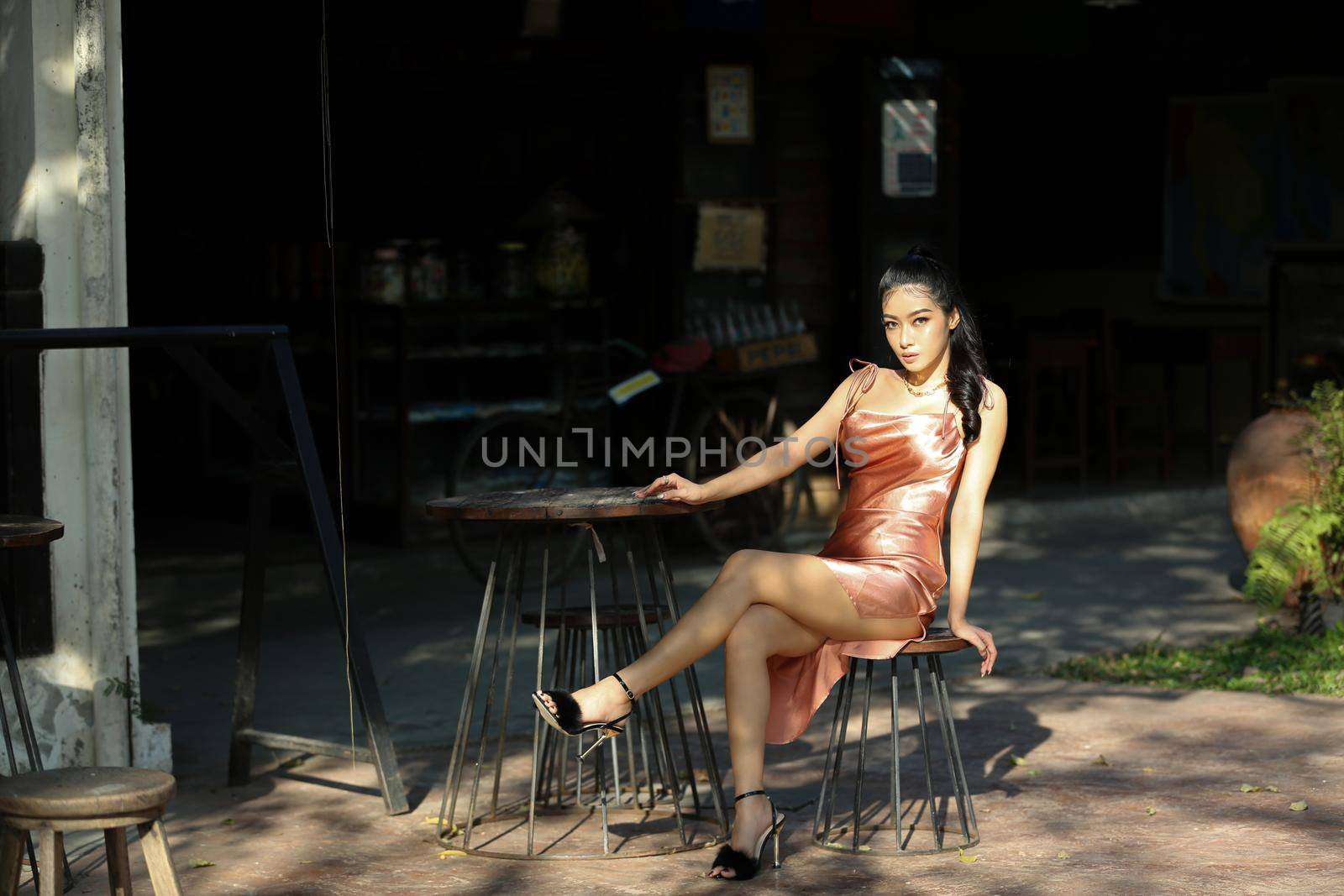 elegant sensual young woman in brown dress on recamier outdoor shot