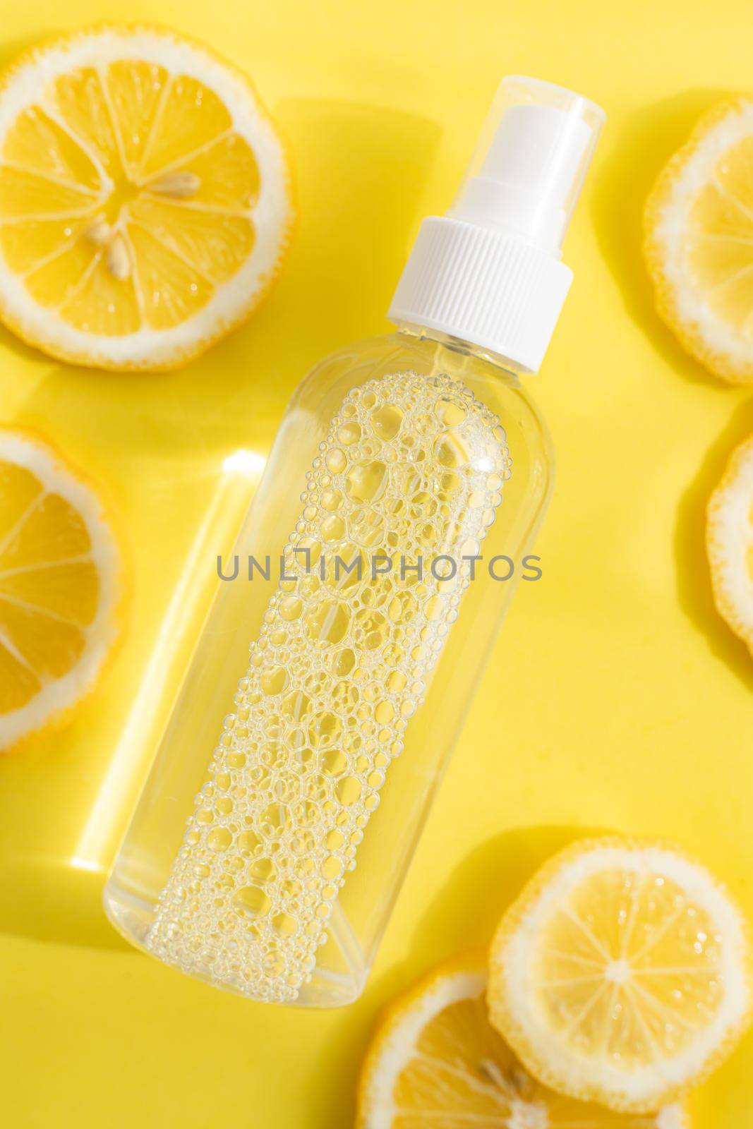 Antiseptic and lemons on a yellow background . Antiseptic for hands. Health and Medicine