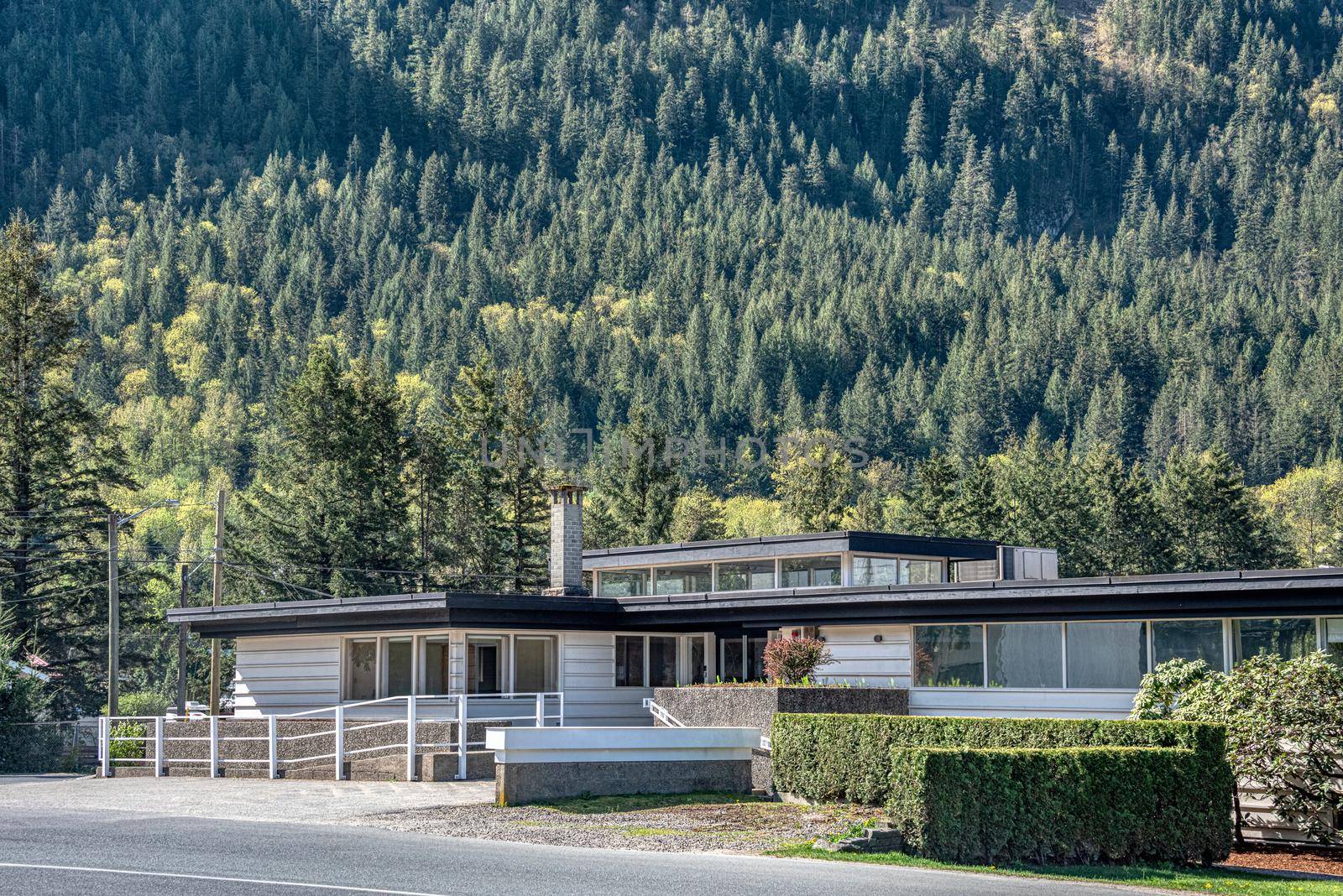A perfect neighbourhood. Office building on mountain slope background.