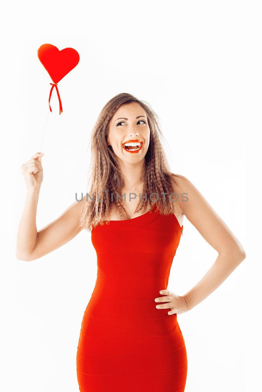 Beautiful cheerful girl standing and holding red heart.