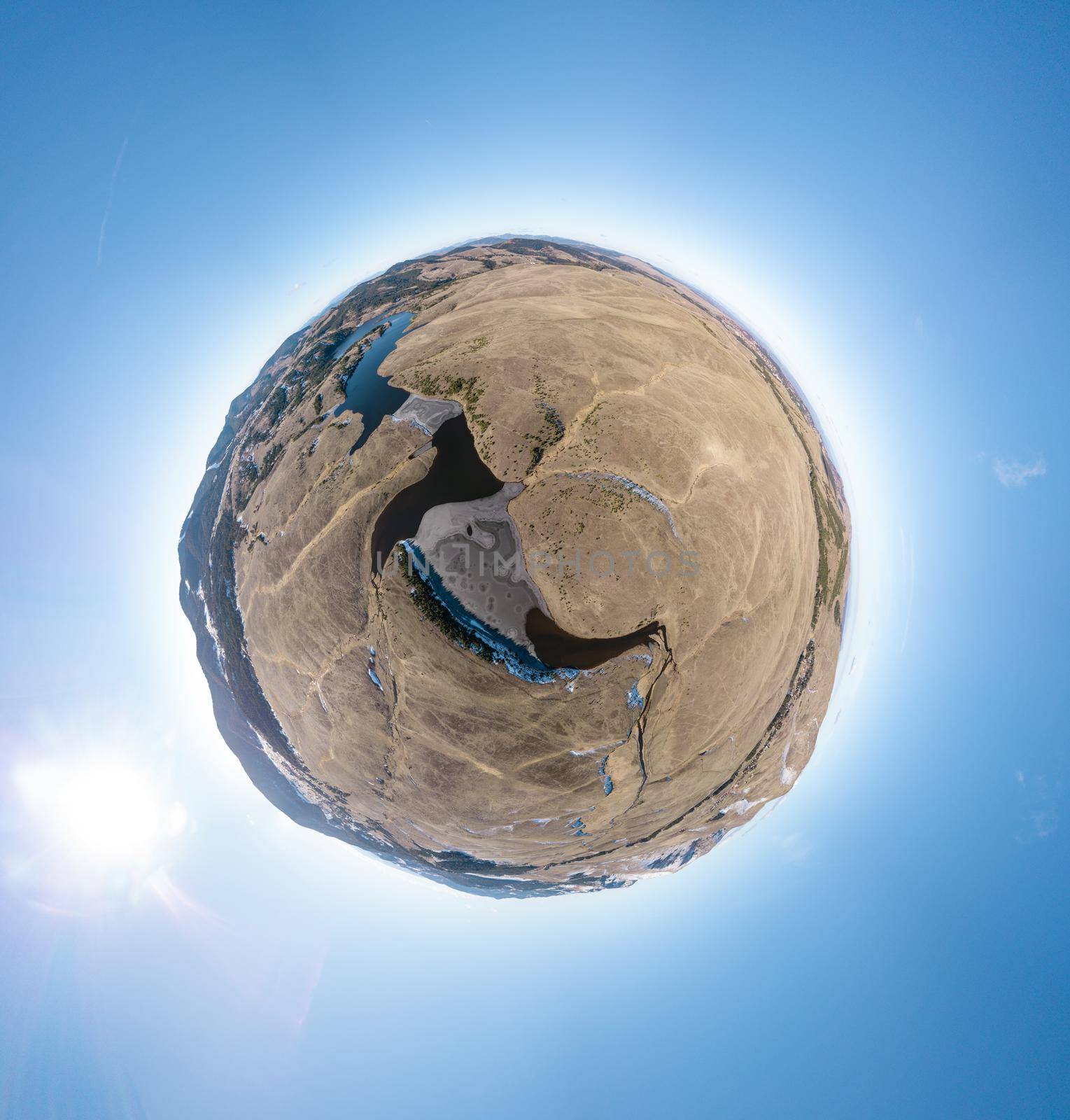Spherical panorama of a little planet with mountains lakes and rivers on a blue sky background.