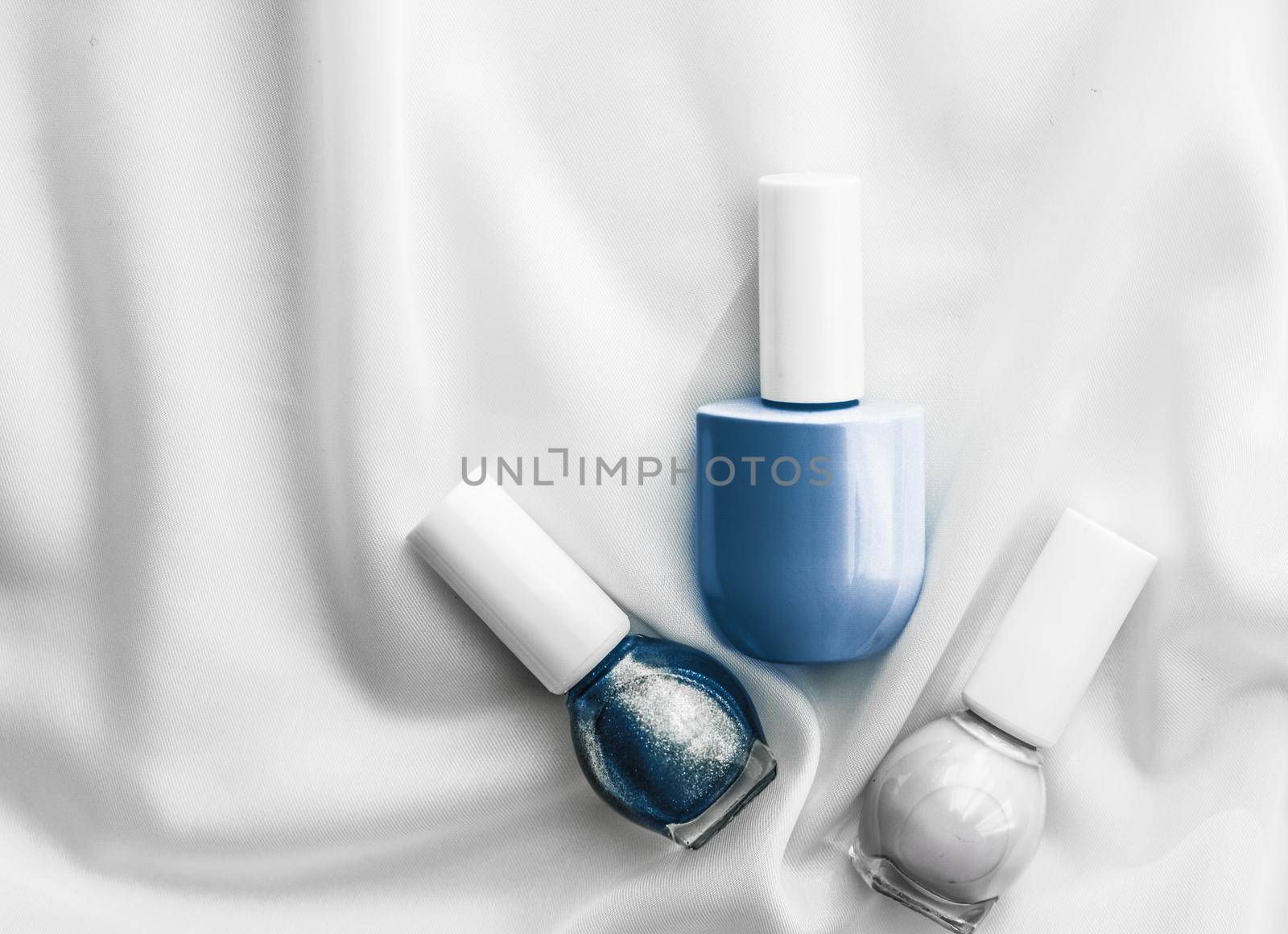 Cosmetic branding, salon and glamour concept - Nail polish bottles on silk background, french manicure products and nailpolish make-up cosmetics for luxury beauty brand and holiday flatlay art design