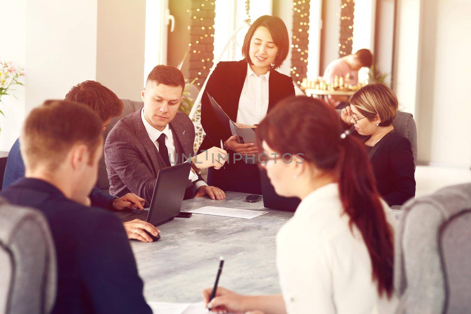 Group of young successful businessmen lawyers communicating together in a conference room while working on a project by selinsmo