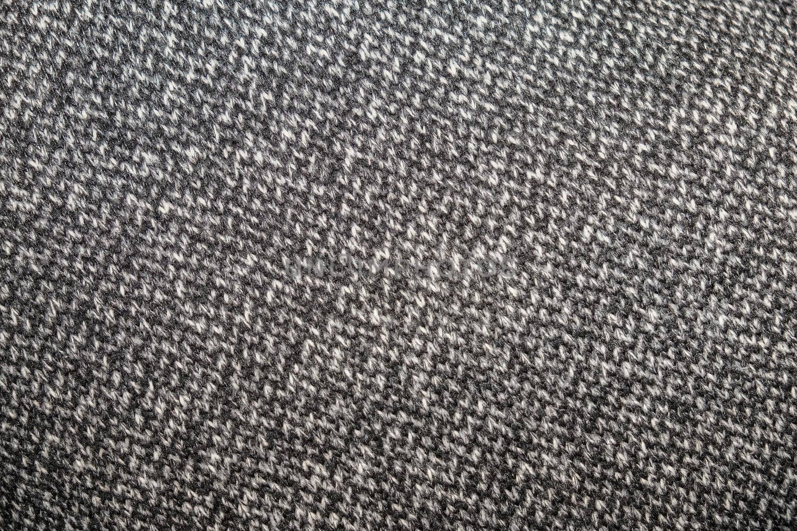 Heather grey knitted fabric made of synthetic yarn. Textured background.