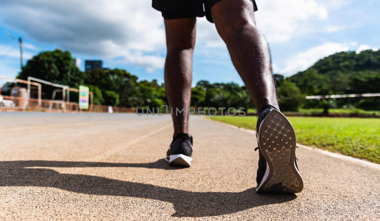 Asian young athlete sport runner black man wear feet active ready to running training at the outdoor on the treadmill line road for a step forward, healthy exercise workout, closeup back shoe