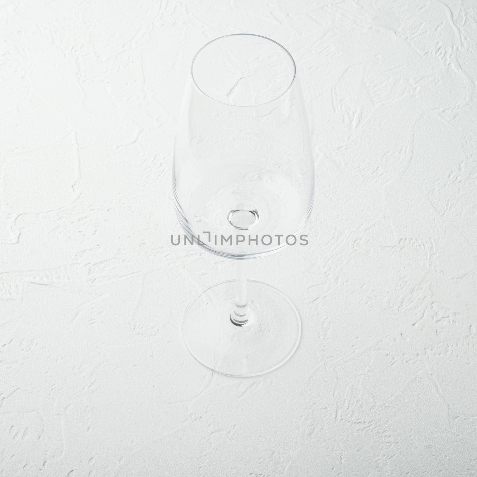 Clean wine glass, square format, on white stone background by Ilianesolenyi