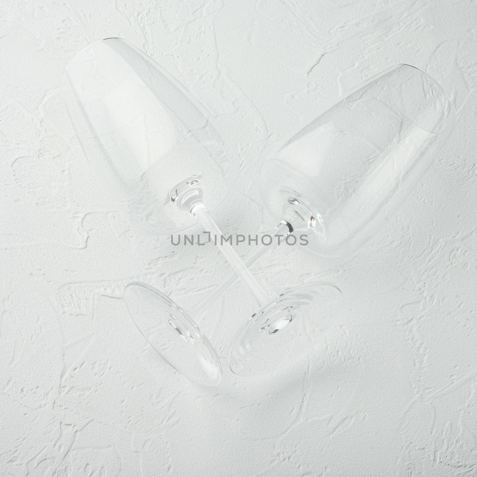 Clean wine glass set, square format, on white stone background