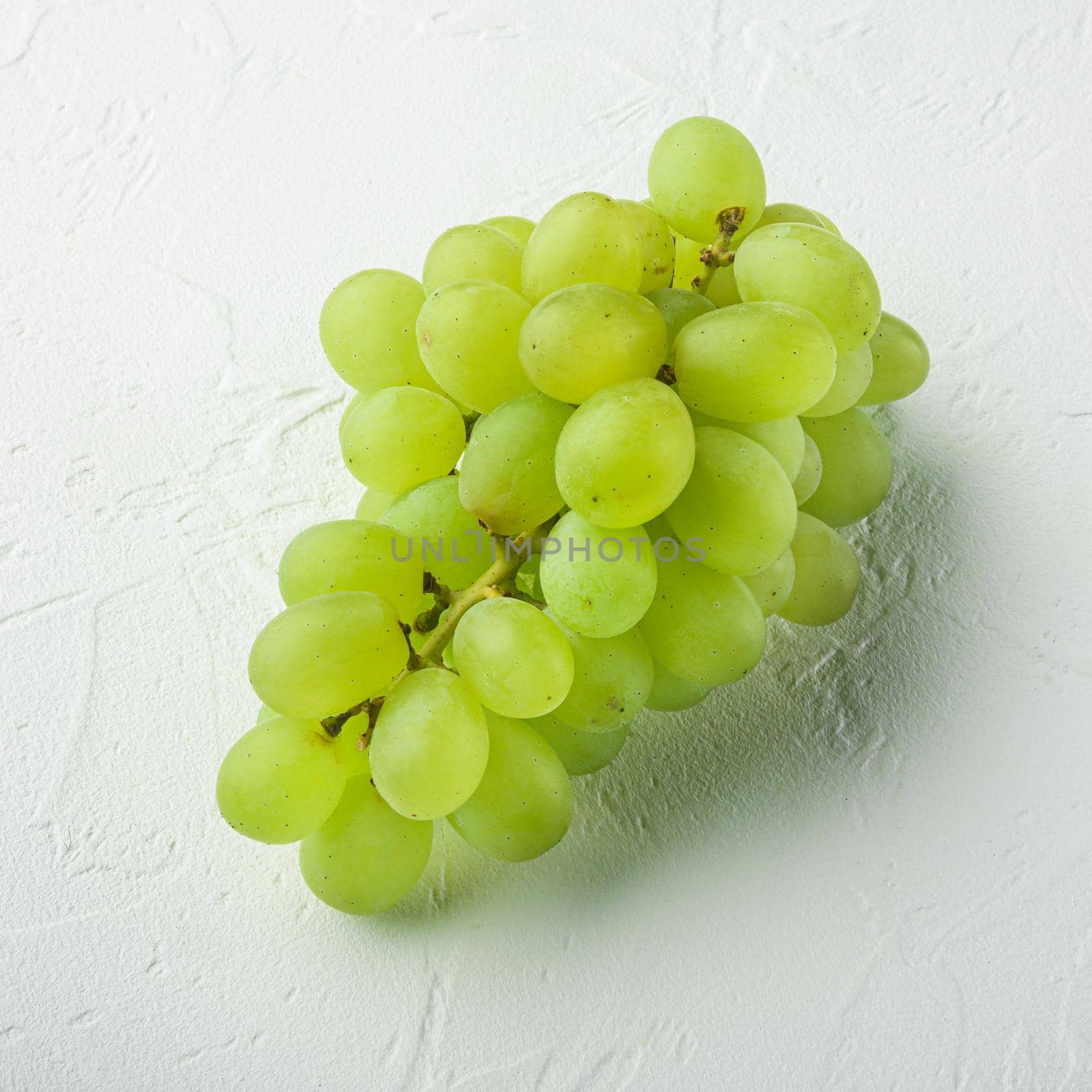 Natural organic juicy grapes, green fruits, square format, on white stone background by Ilianesolenyi