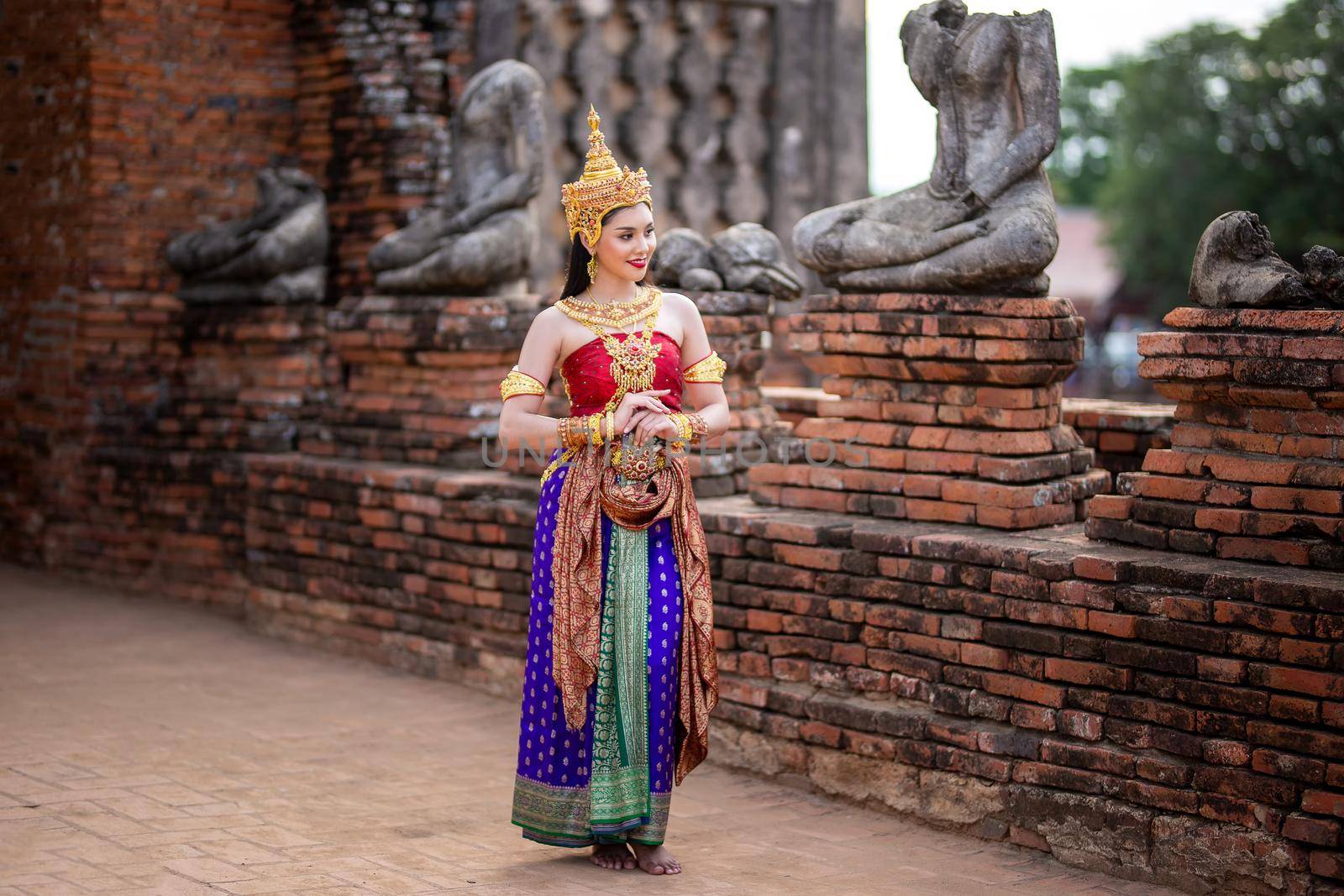 Thailand or Thai costume Asian dress concept. Young Thai beautiful woman is walking in the Buddhist temple in Ayutthaya. by chuanchai