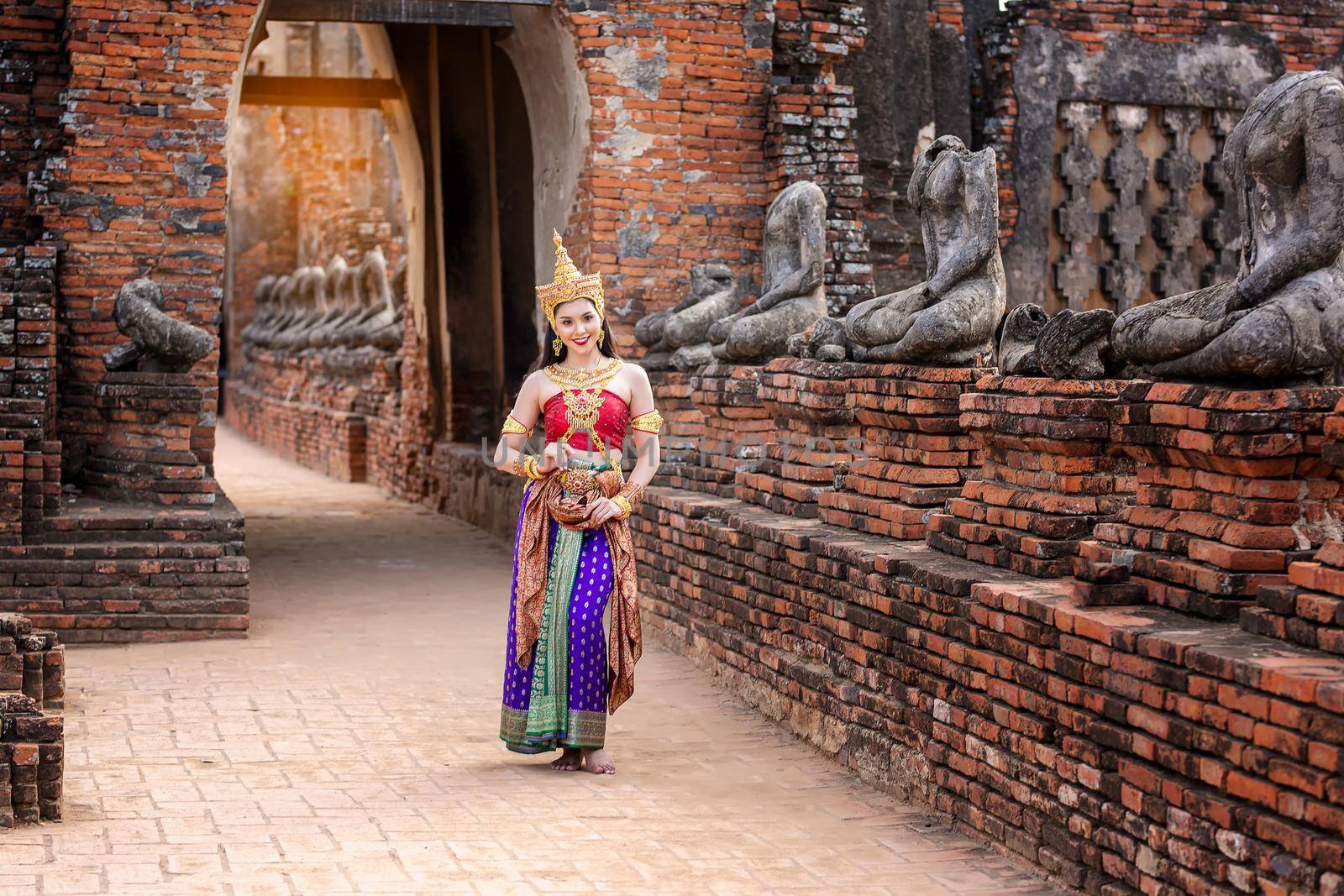 Thailand or Thai costume Asian dress concept. Young Thai beautiful woman is walking in the Buddhist temple in Ayutthaya. by chuanchai