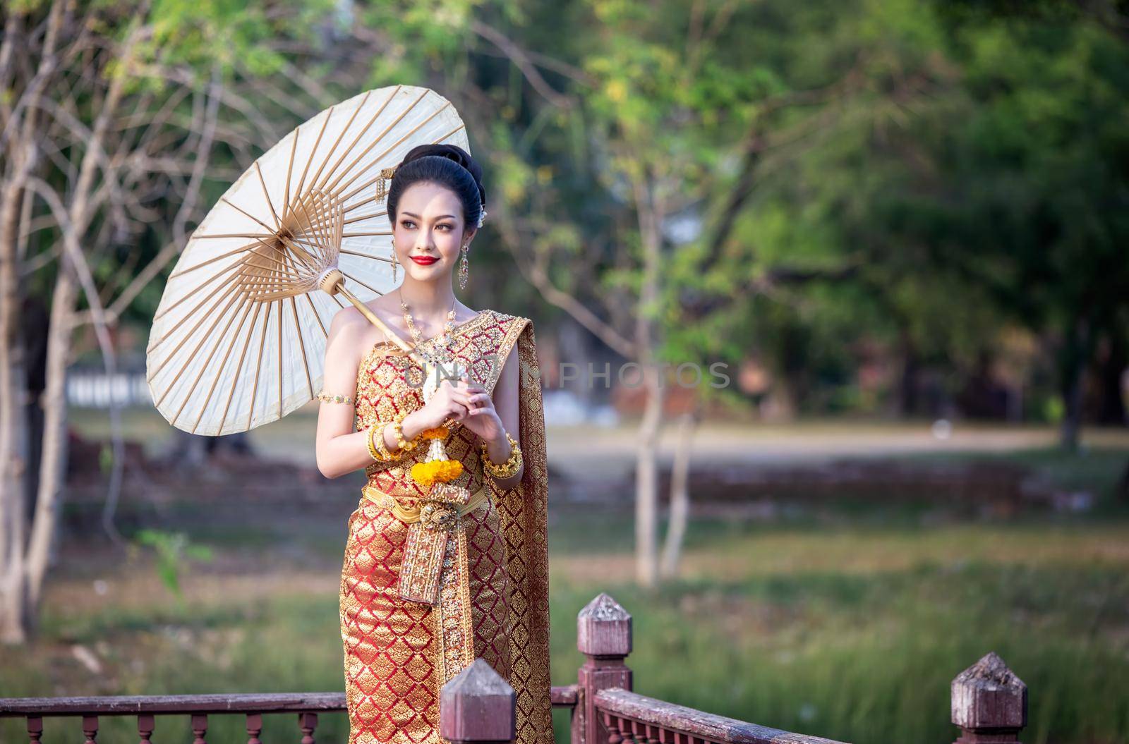 Thailand or Thai costume Asian dress concept. Young Thai beautiful woman is walking in the Buddhist temple in Ayutthaya. by chuanchai