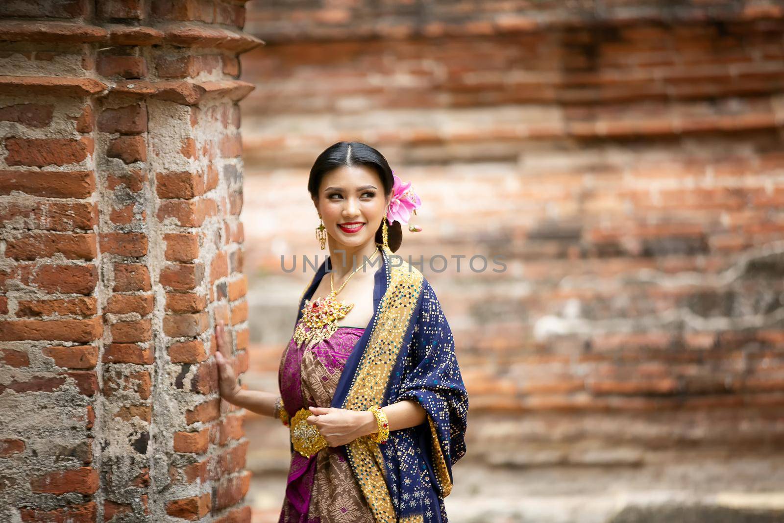Indonesia Young beautiful woman with Traditional dress standing and look at camera at Gate to heaven Handara Golf Gate in Bedugul, Bali ,Indonesia.