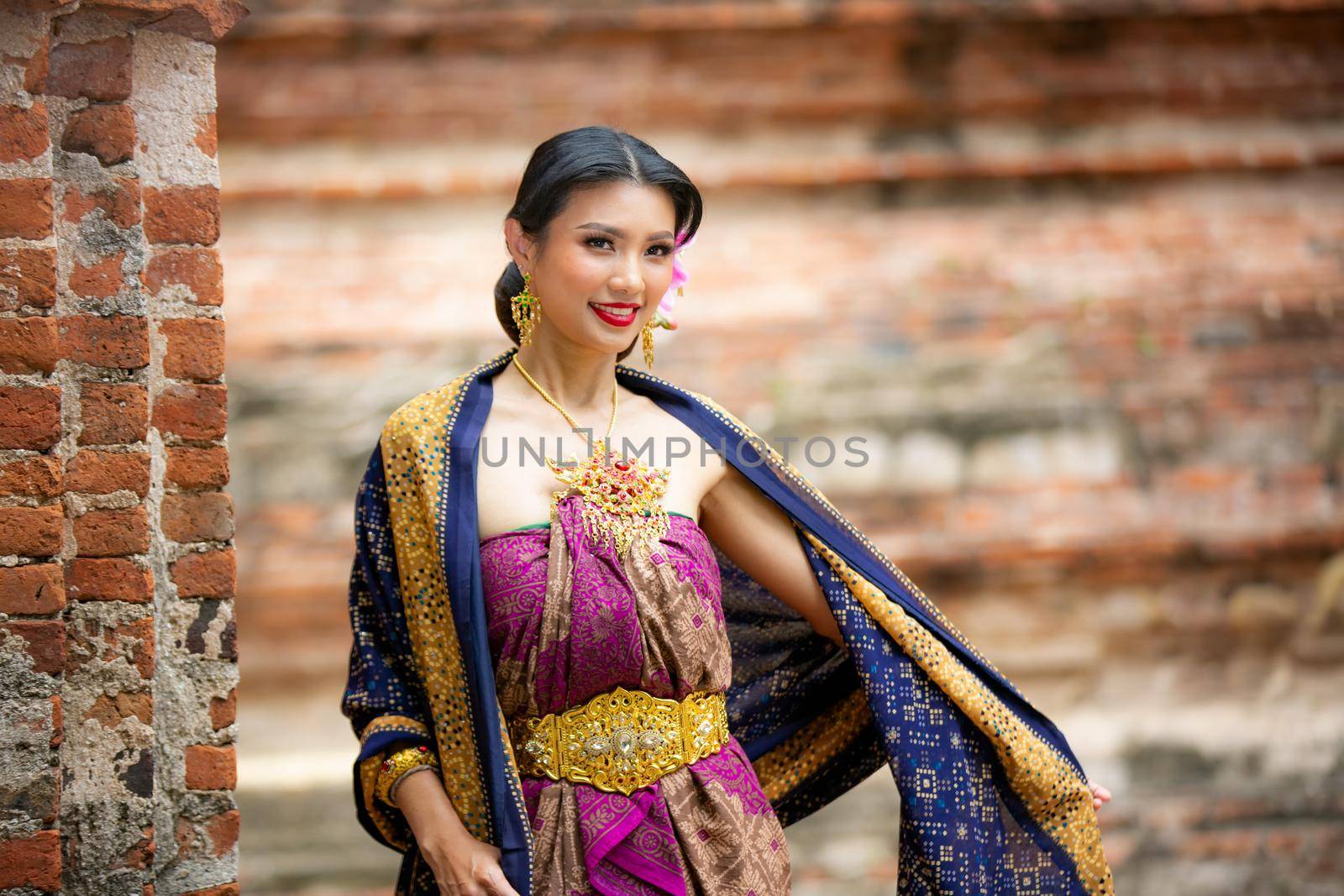 Indonesia Young beautiful woman with Traditional dress standing and look at camera at Gate to heaven Handara Golf Gate in Bedugul, Bali ,Indonesia.