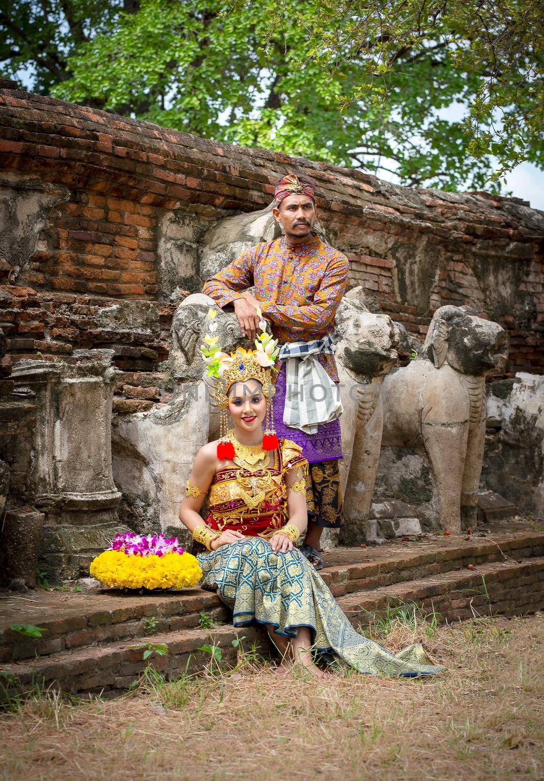 Portrait Of Smiling Young Woman In Balinese Traditional Clothing Holding Flower Bouquet At Temple by chuanchai