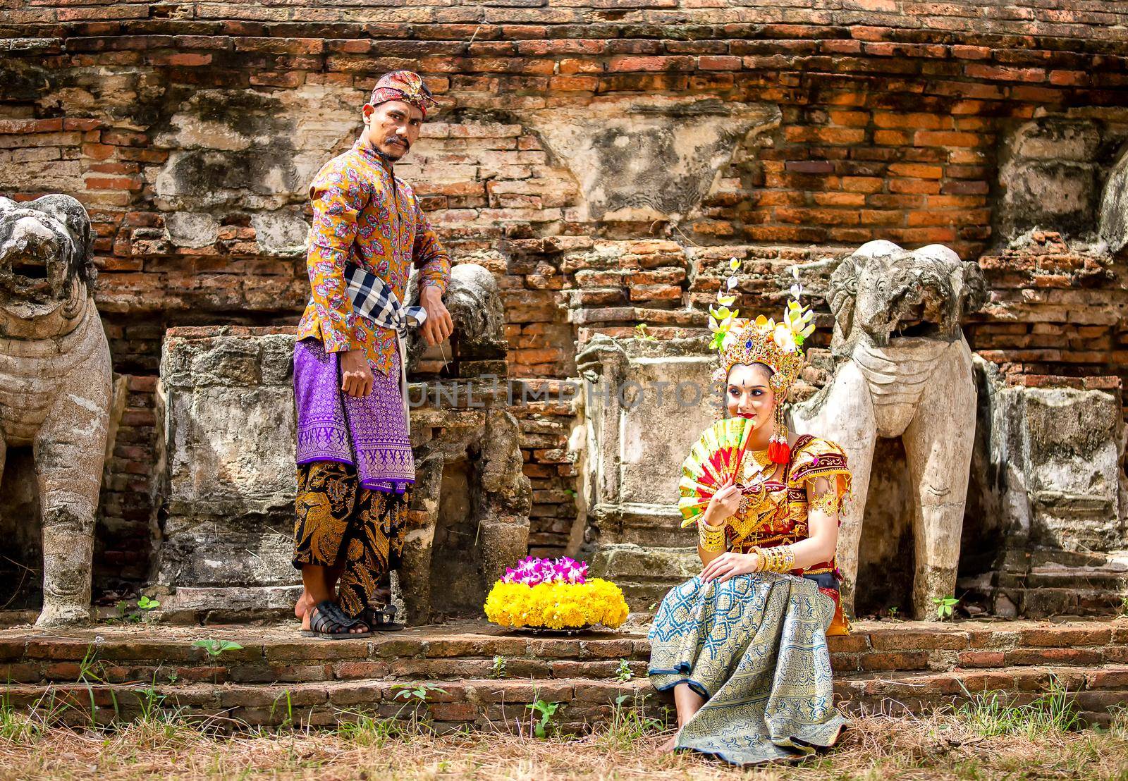 Portrait Of Smiling Young Woman In Balinese Traditional Clothing Holding Flower Bouquet At Temple by chuanchai