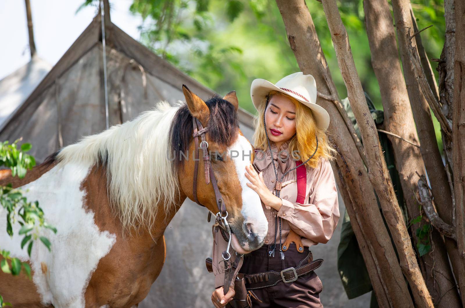 Cowgirl standing by horse, westlife and outdoor. by chuanchai