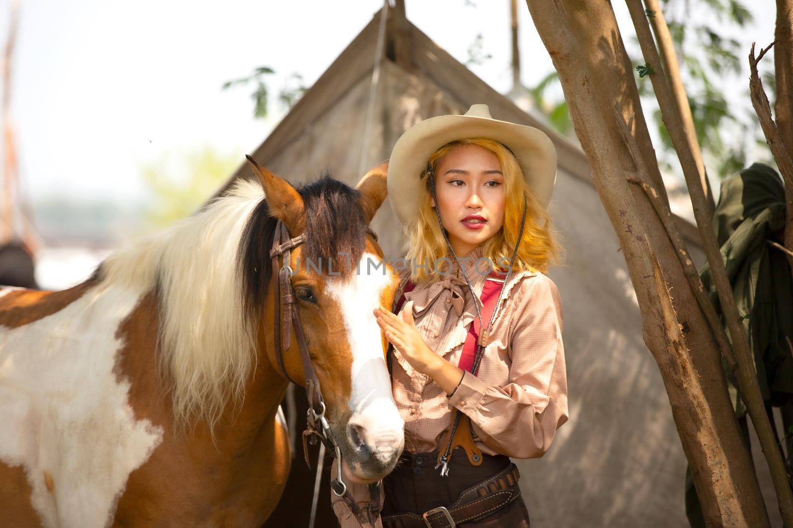 Cowgirl standing by horse, westlife and outdoor. by chuanchai